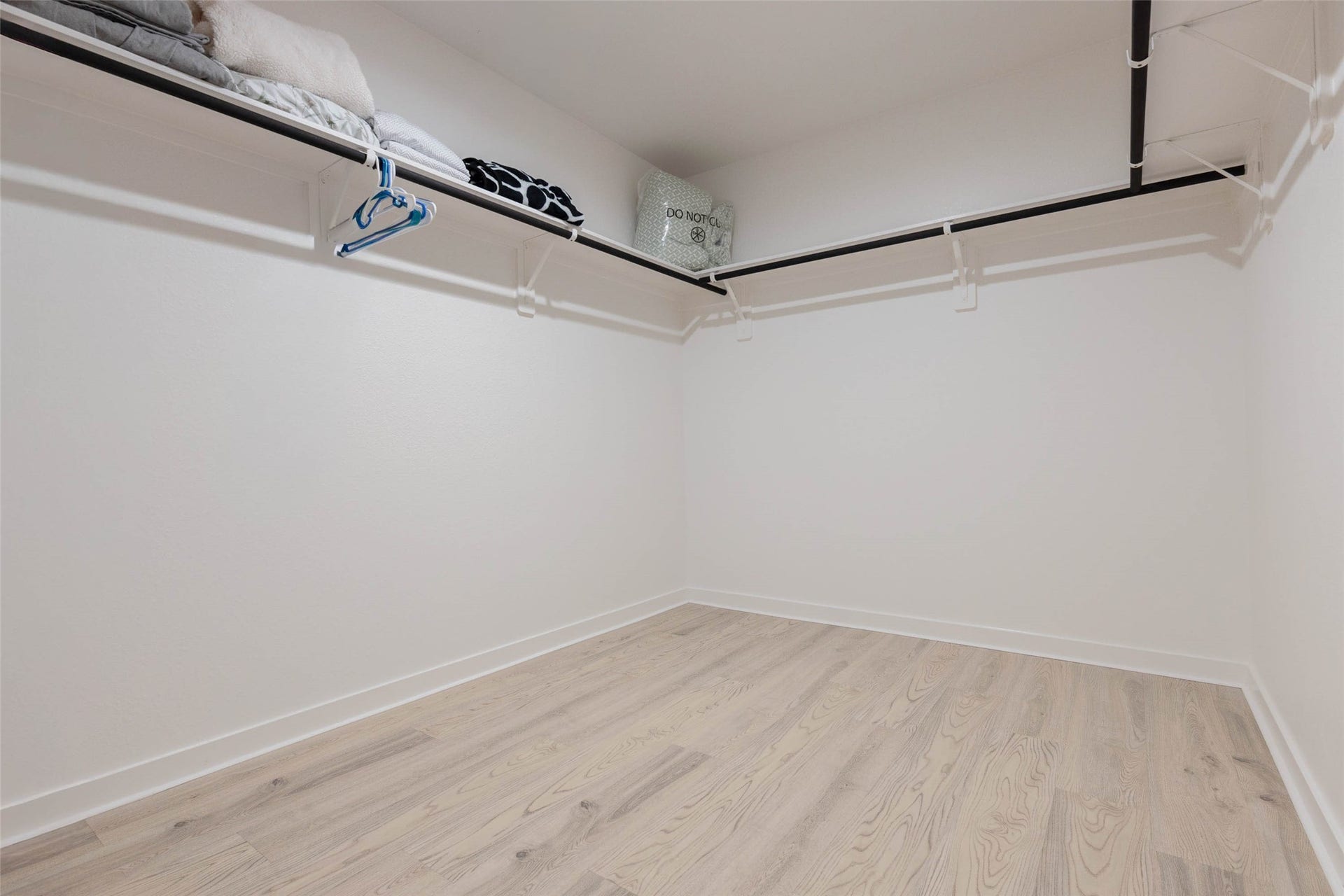 30502 White Cliff Court, Fulshear, TX 77441 Spacious walk-in closet featuring ample hanging space and sleek hardwood flooring, perfect for organizing your wardrobe.