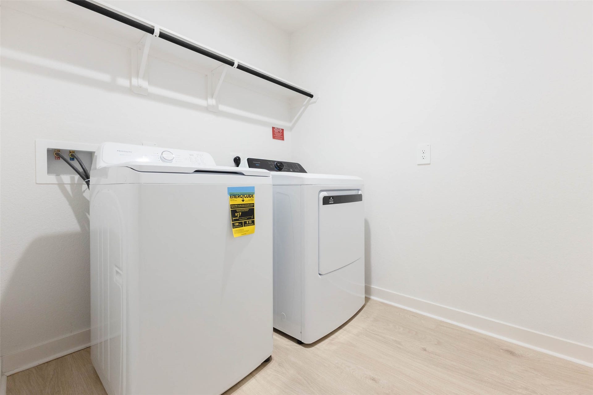 30502 White Cliff Court, Fulshear, TX 77441 Modern laundry room featuring a washer and dryer set, complete with a convenient overhead shelf for storage.