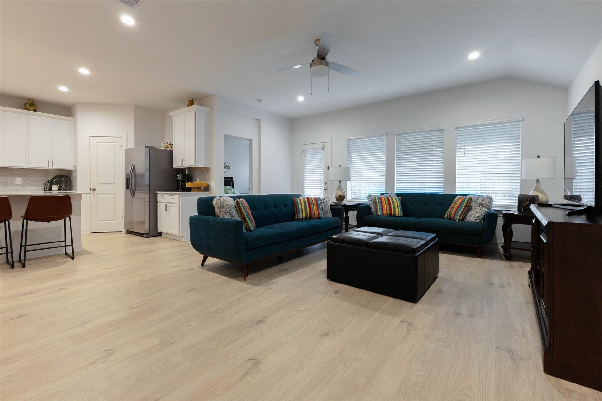 30502 White Cliff Court, Fulshear, TX 77441 Spacious open-concept living area with modern kitchen, featuring sleek cabinetry, stainless steel appliances, and a cozy seating area.