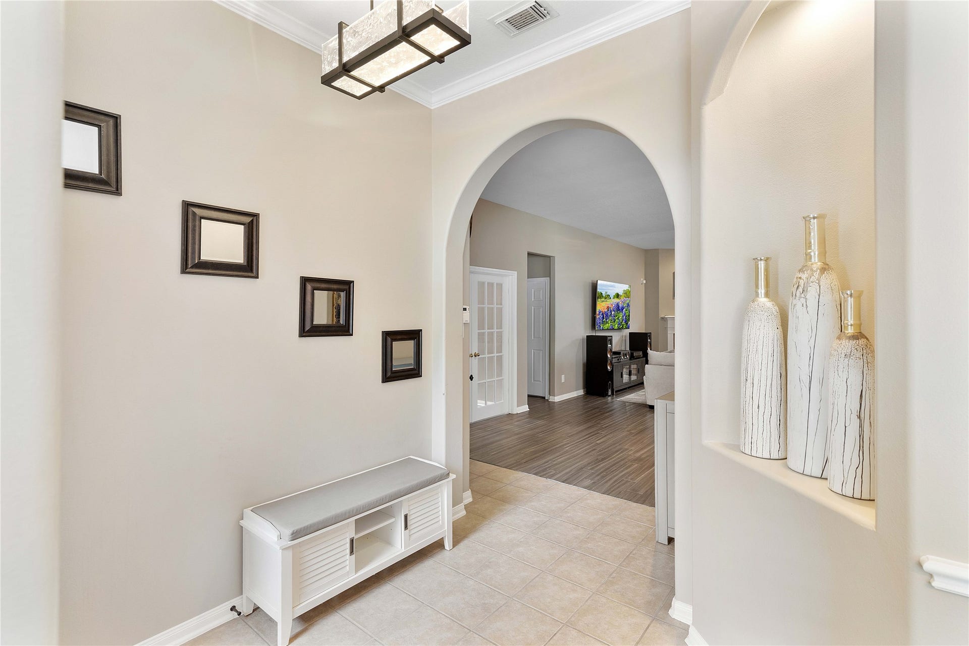 18343 Otter Creek Trail, Humble, TX 77346 Elegant entryway featuring an arched doorway, modern lighting leading to an inviting living space.