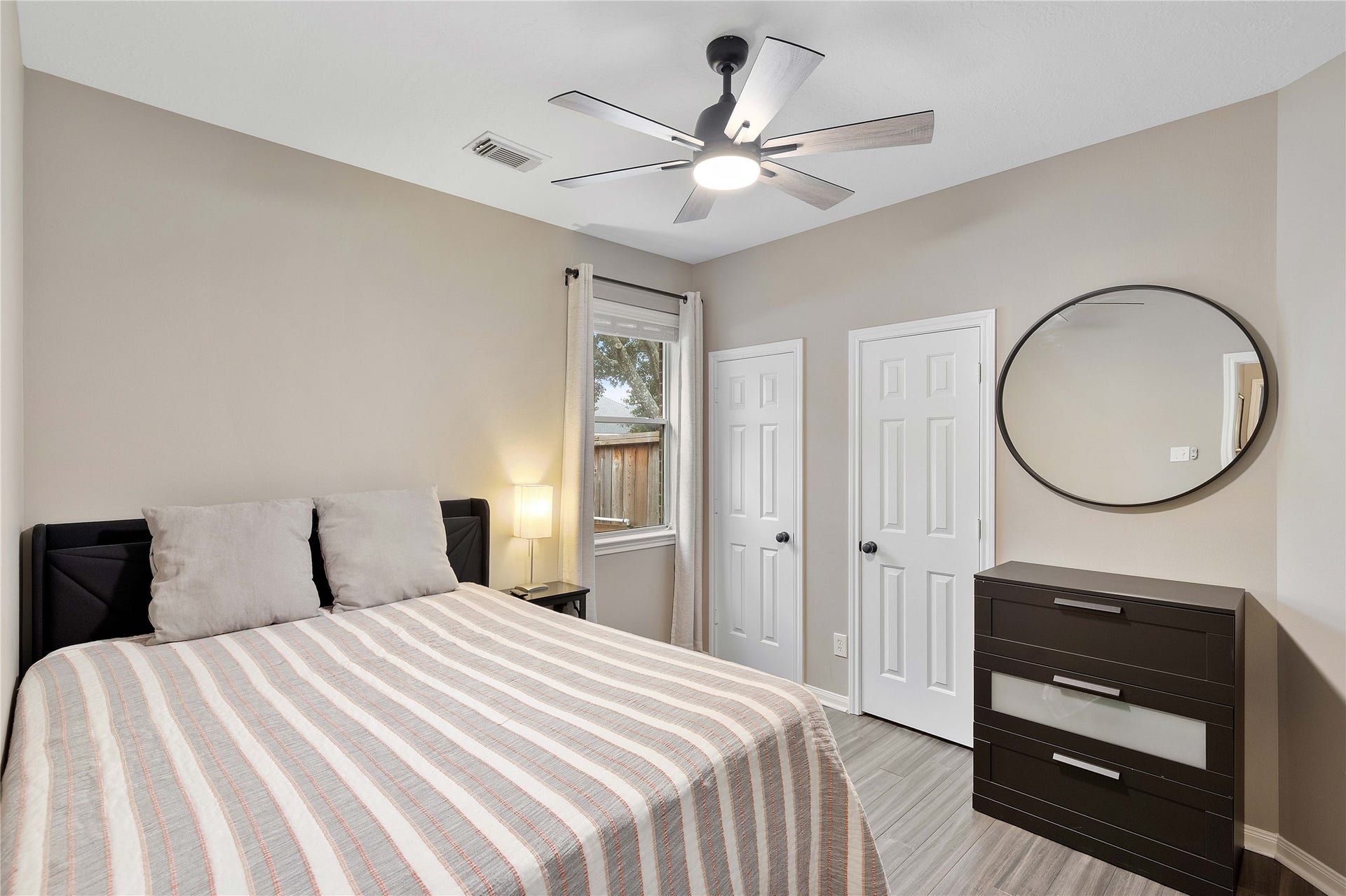 18343 Otter Creek Trail, Humble, TX 77346 Cozy guest bedroom featuring a sleek ceiling fan and ample storage.