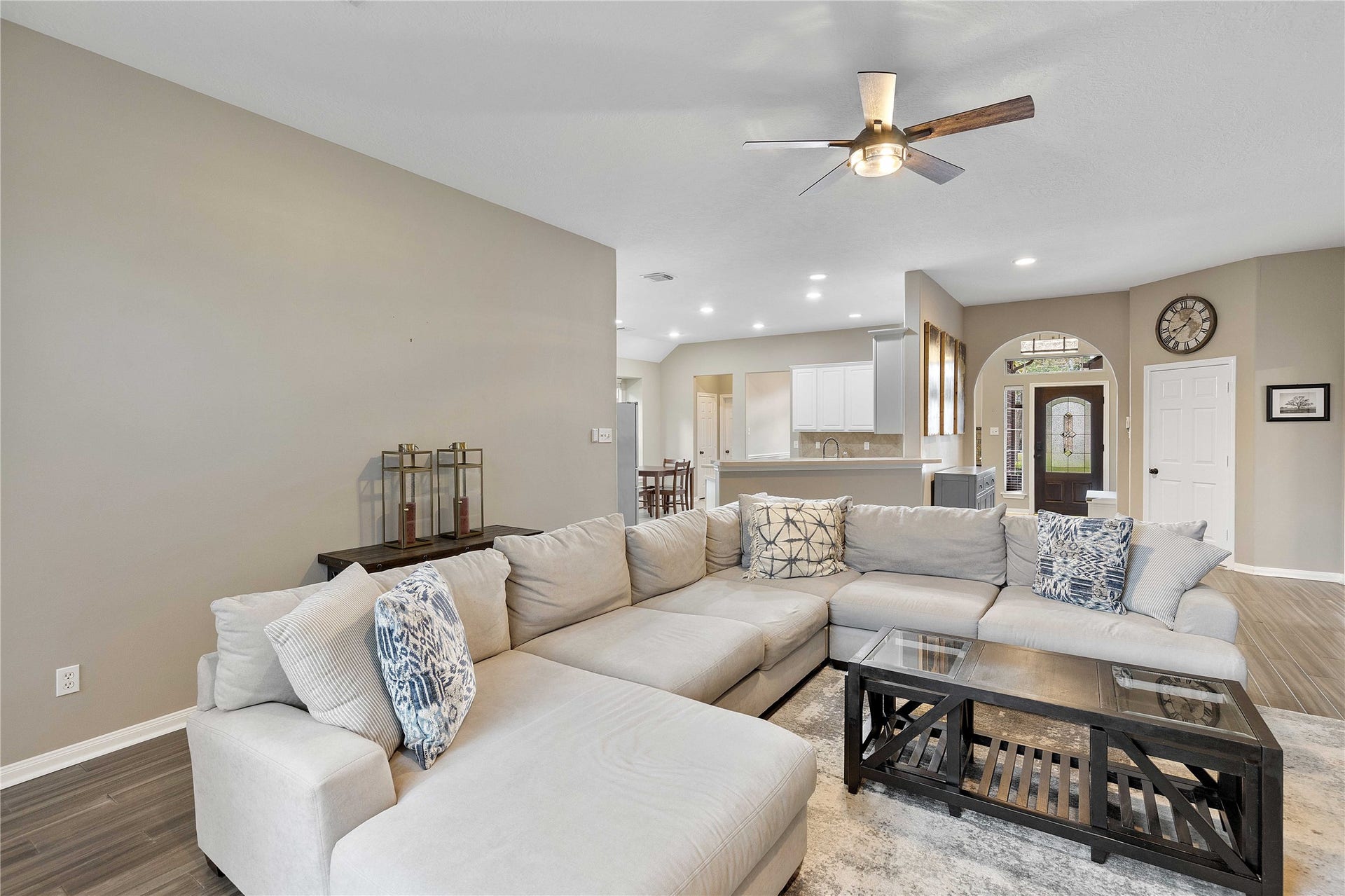 18343 Otter Creek Trail, Humble, TX 77346 Spacious living area with, a modern ceiling fan, and an open layout that connects to a bright kitchen.