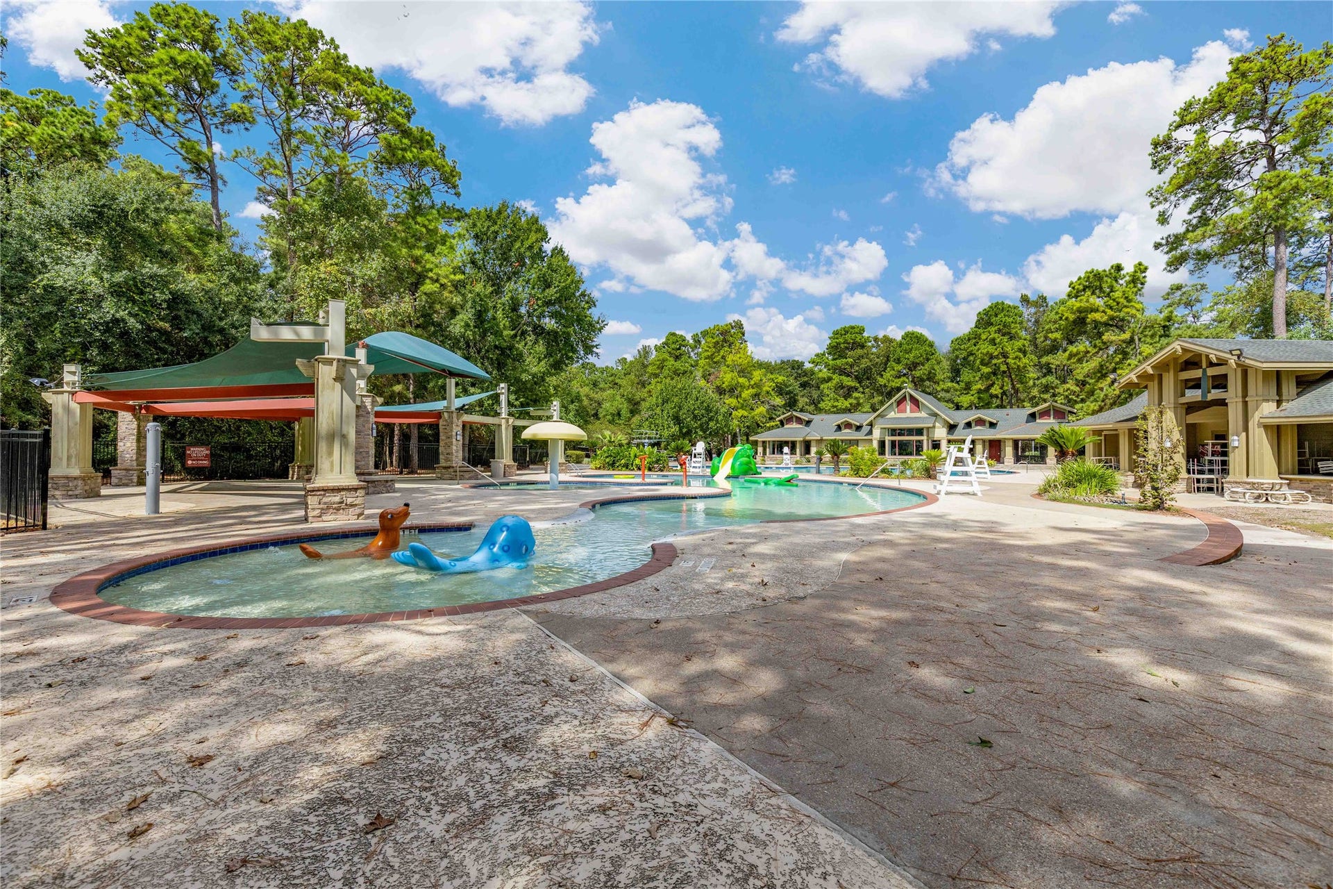 18343 Otter Creek Trail, Humble, TX 77346 Enjoy vibrant community living with a spacious pool area, playful water features, and shaded lounging spaces, nestled amidst lush greenery.