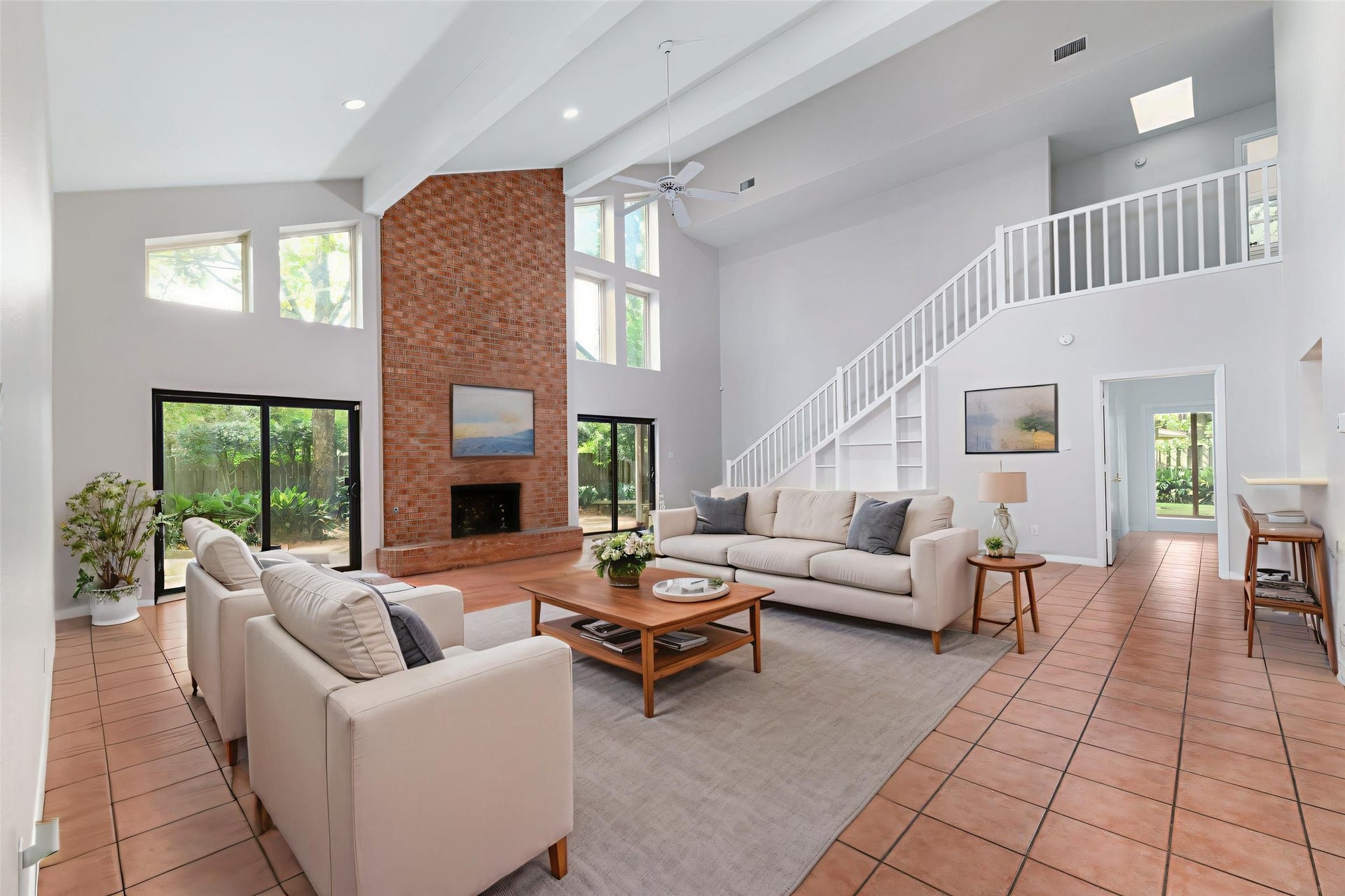 904 Winston Drive, Richmond, TX 77469 The family room is enormous! Offering soaring vaulted ceilings open to the second floor, convenient built-ins, and a floor-to-ceiling brick fireplace with raised hearth. (photo has been digitally staged to show the potential of the space)
