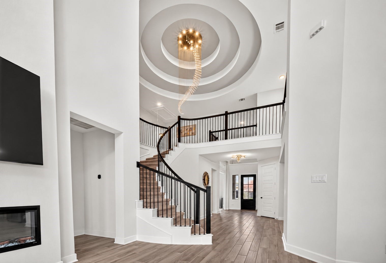 2511 Falling Fig Lane, Richmond, TX 77406 A breathtaking curved staircase makes a grand architectural statement, complemented by an exquisite chandelier that adds elegance, drama, and timeless luxury to the homes interior