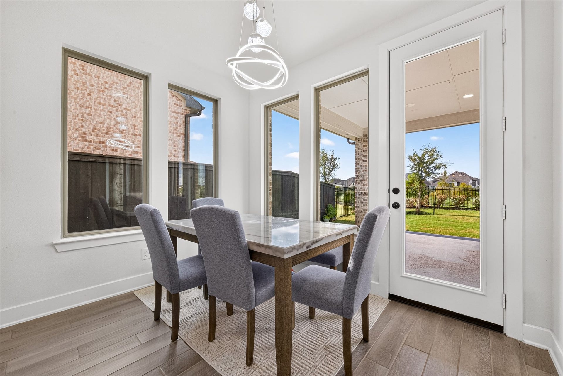 2511 Falling Fig Lane, Richmond, TX 77406 A sunlit breakfast area featuring expansive windows with serene views of the backyard and direct access to the patio, offering an elegant setting for casual dining and effortless indoor-outdoor living