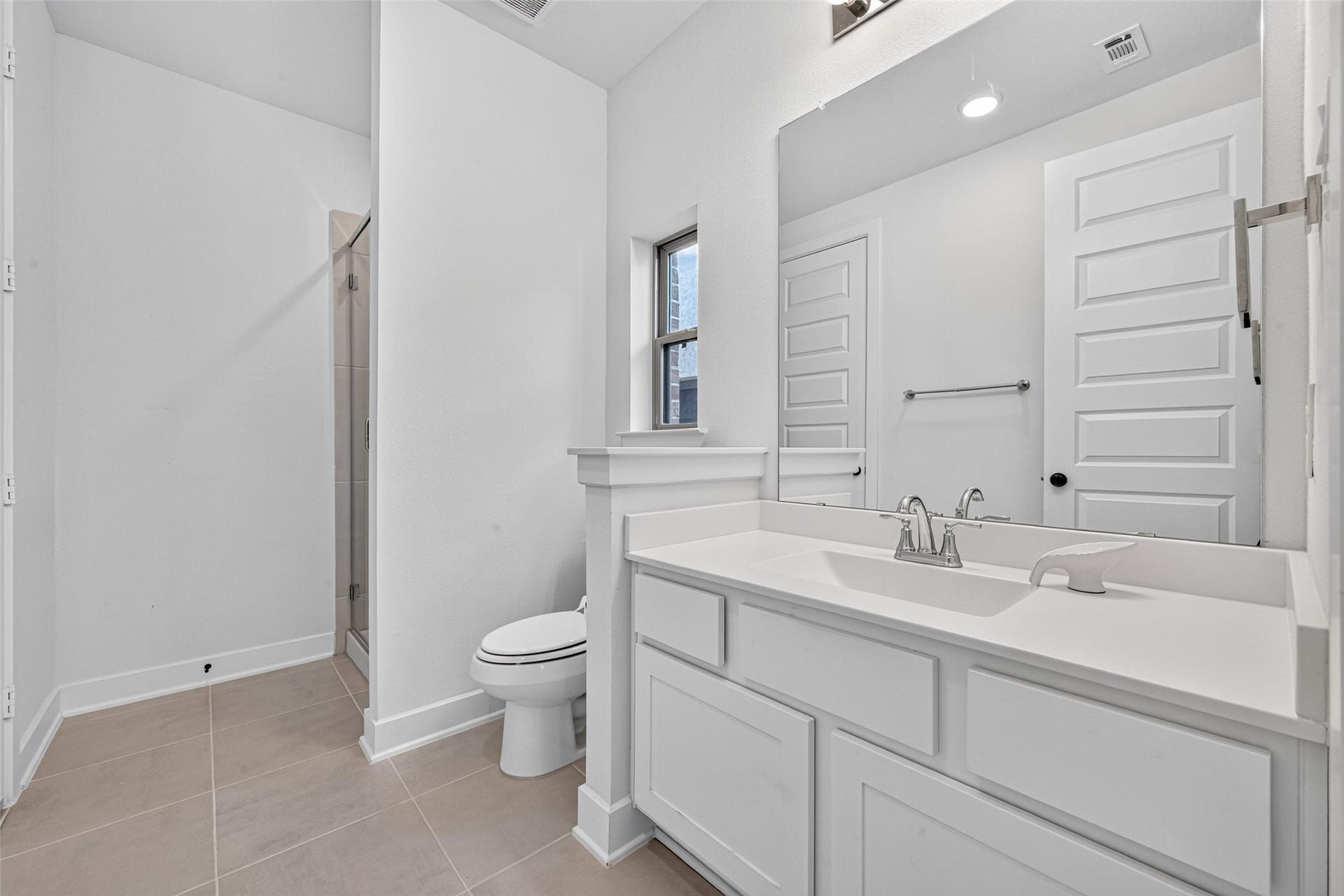 2511 Falling Fig Lane, Richmond, TX 77406 The guest bedrooms private en-suite features a spacious vanity with ample counter space, blending everyday functionality with a polished, elegant design for added comfort and convenience