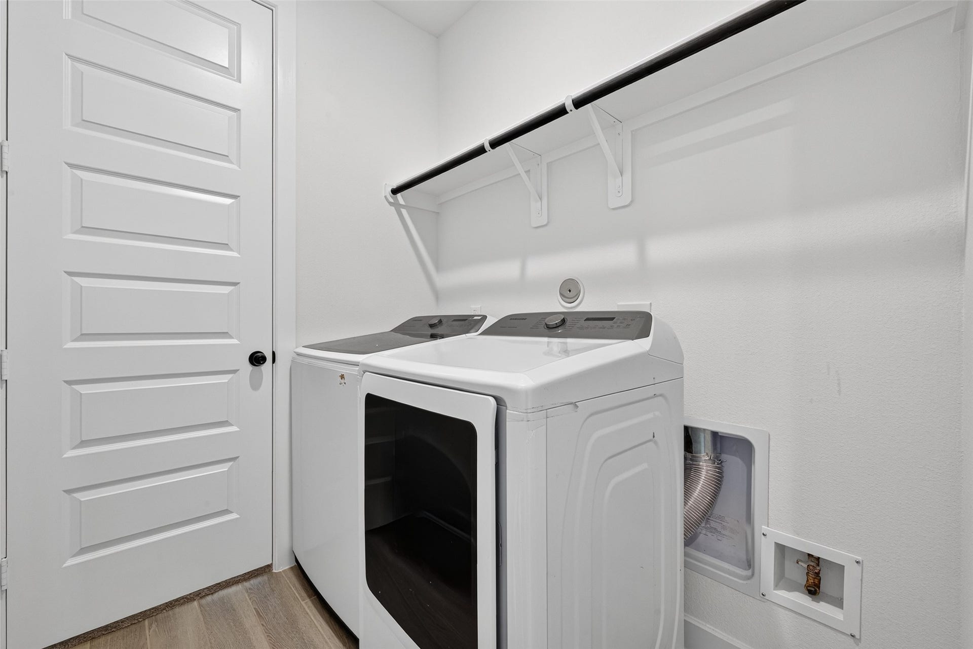 2511 Falling Fig Lane, Richmond, TX 77406 A well-appointed laundry room featuring a convenient built-in shelf for added storage and organization, combining everyday functionality with a clean, polished design