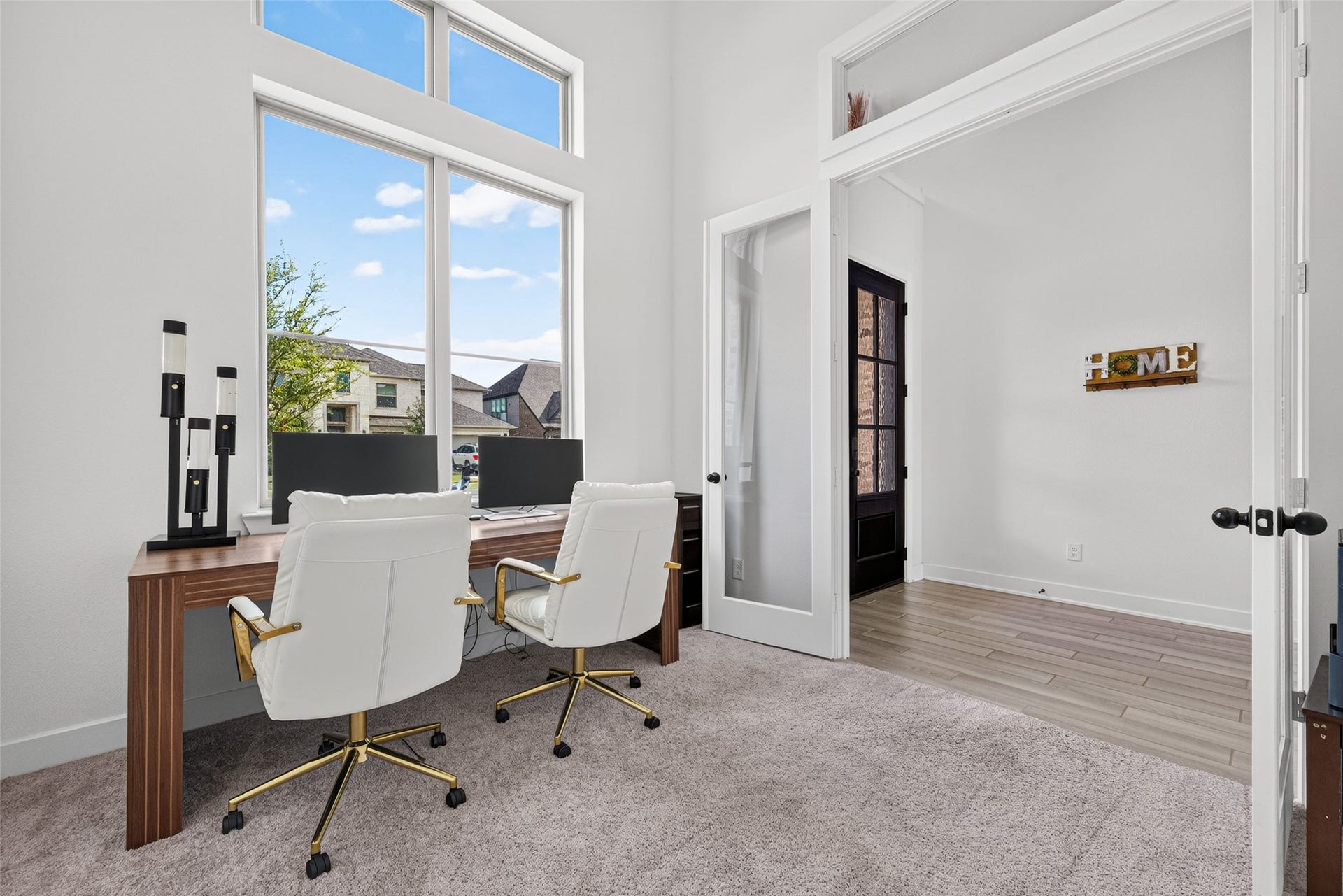 2511 Falling Fig Lane, Richmond, TX 77406 A distinguished executive-style home office featuring elegant glass French doors and a dramatic wall of windows, creating a refined, light-filled workspace that exudes luxury and sophistication