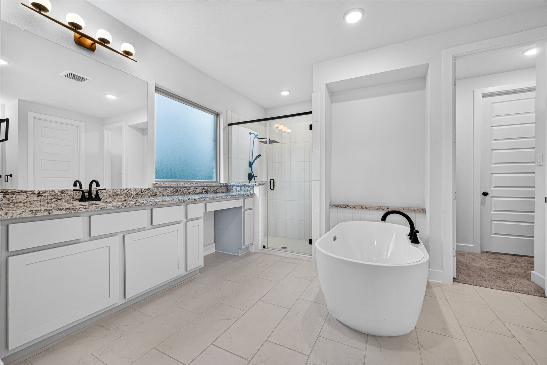 2511 Falling Fig Lane, Richmond, TX 77406 An opulent primary bathroom designed to evoke a five-star spa experience, featuring sophisticated double vanities, an expansive glass-enclosed walk-in shower, and a luxurious freestanding soaking tub, creating an exquisite retreat for relaxation and indulgence