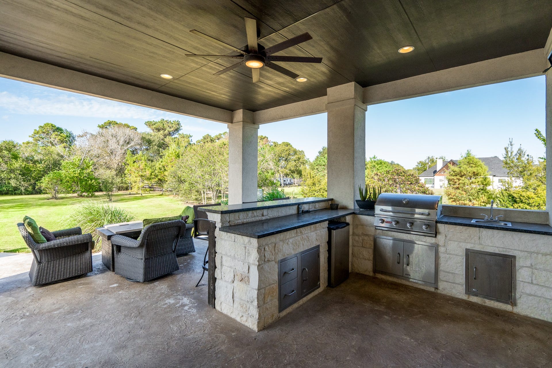 Summer kitchen includes stainless appliances and sink.