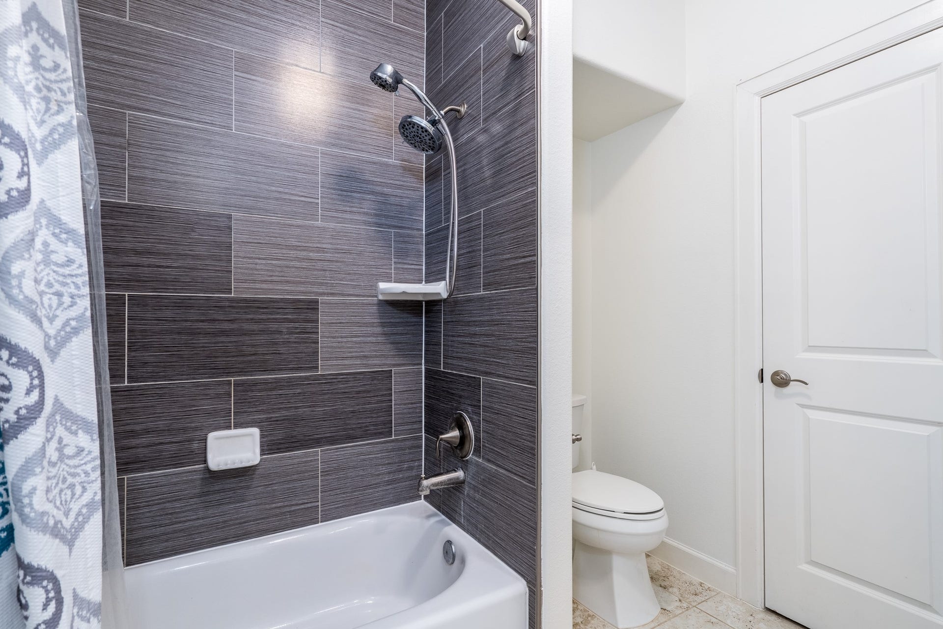 Full bath with tile surround.