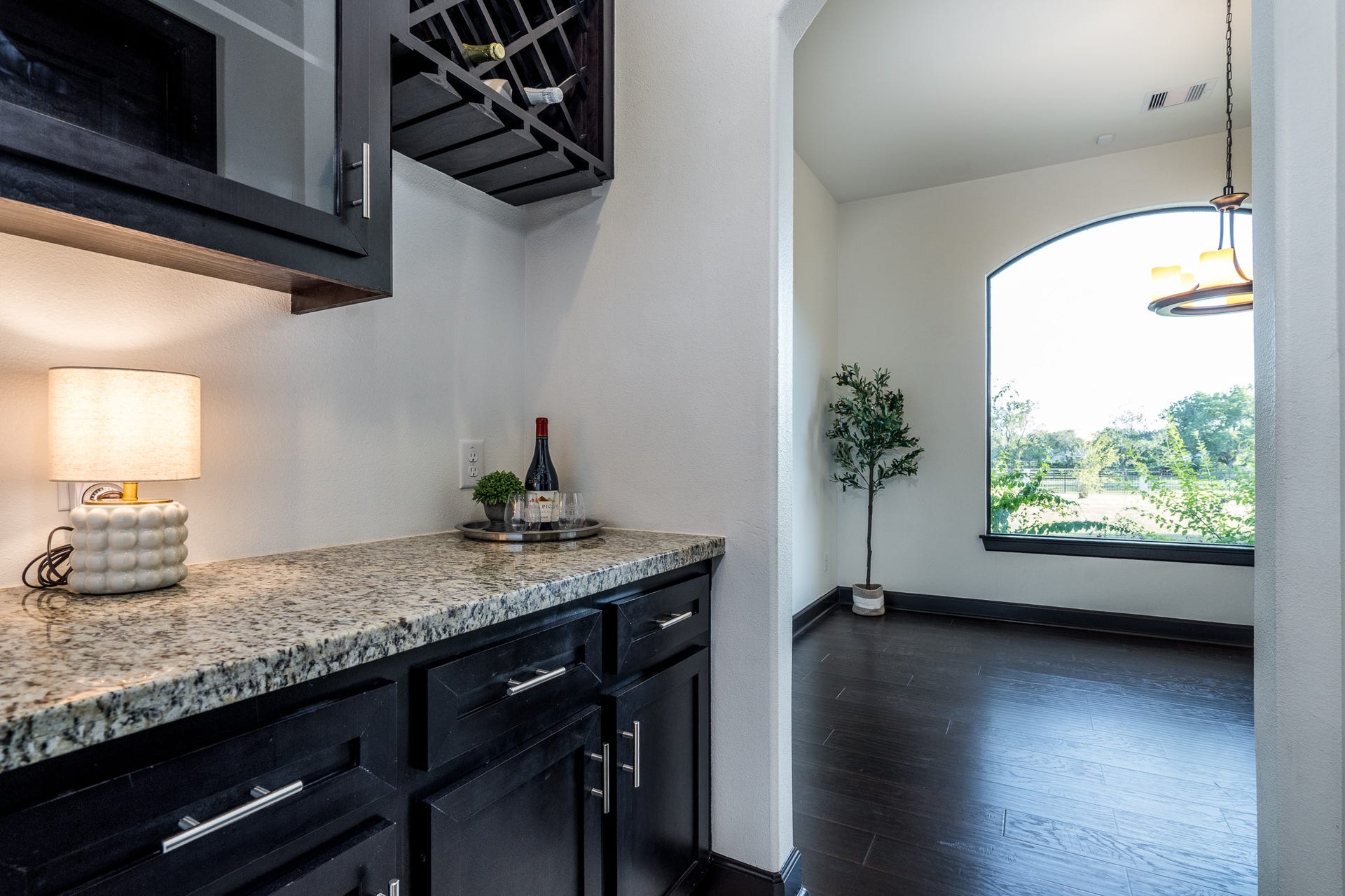Butler's pantry features wine storage, glass front cabinet and granite counter.
