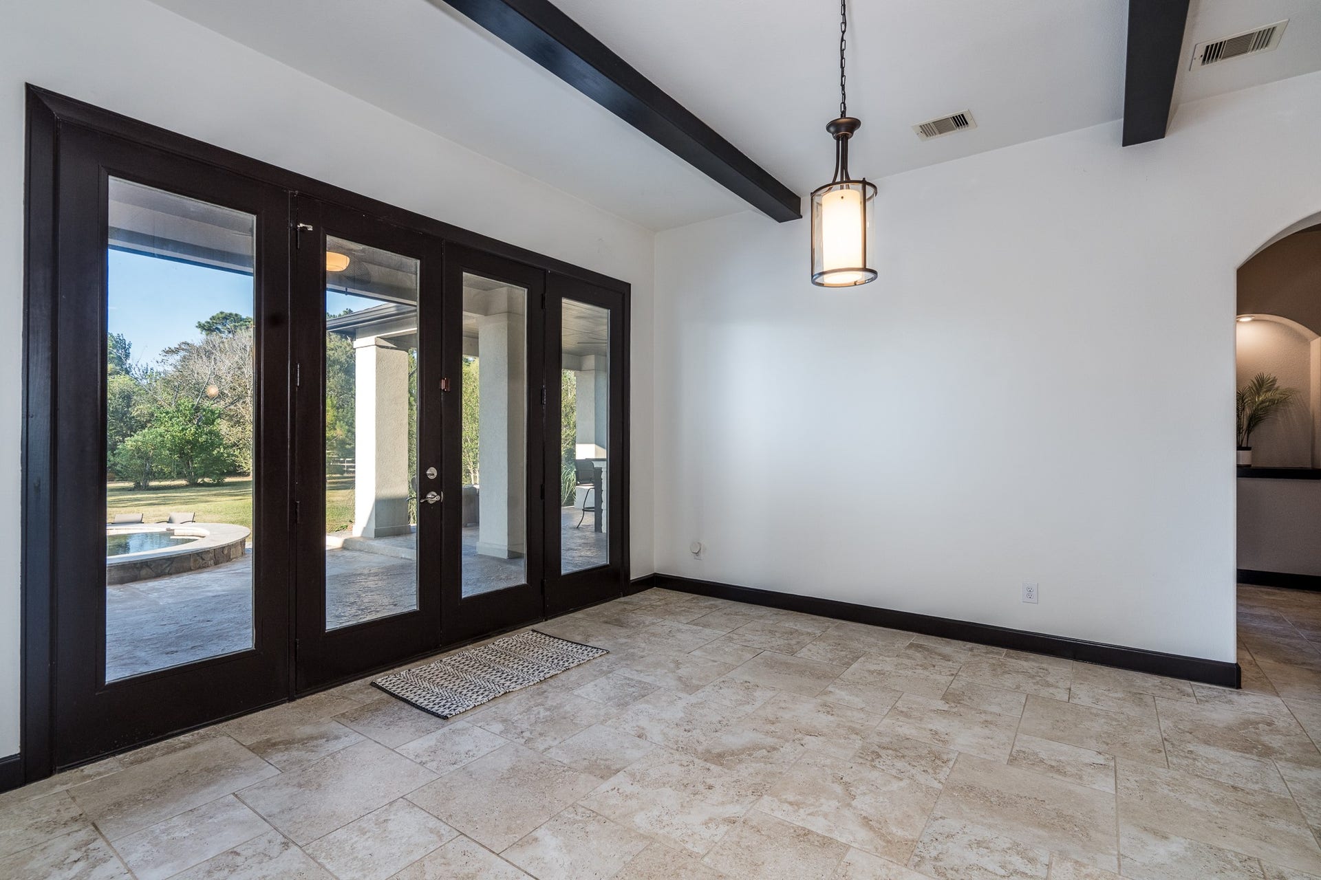 Custom quadruple glass with French doors opening to the nearby summer kitchen and breakfast.