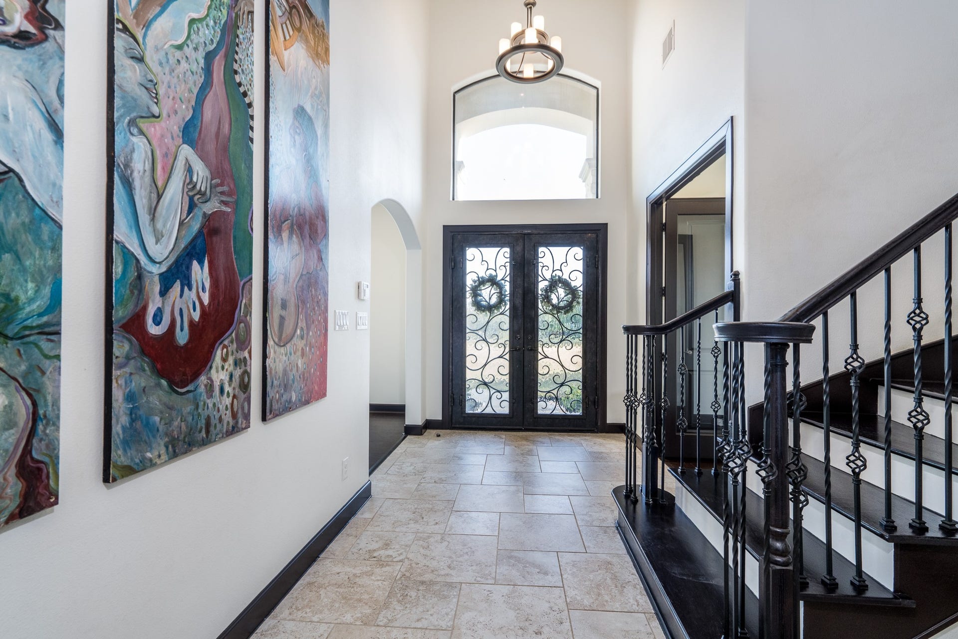 Stunning iron and glass double door entry with high ceiling that can be found in many areas of the home.