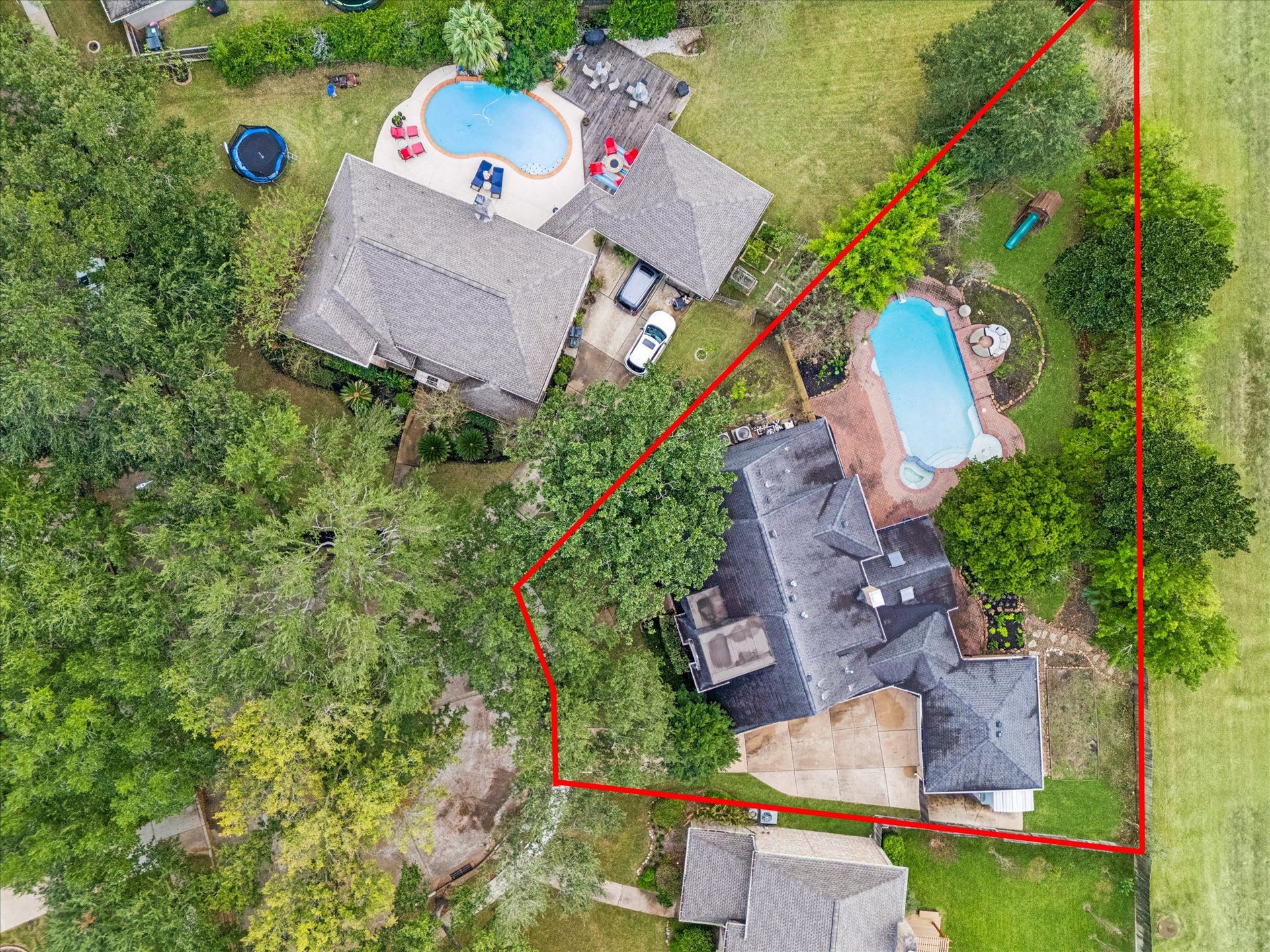 2526 STEPHENS GRANT DRIVE, Sugar Land, TX 77479 This aerial highlights the home's impressively deep, tree-canopied lot, showcasing the main residence and its sprawling, fenced outdoor entertainment area with a large in-ground pool.