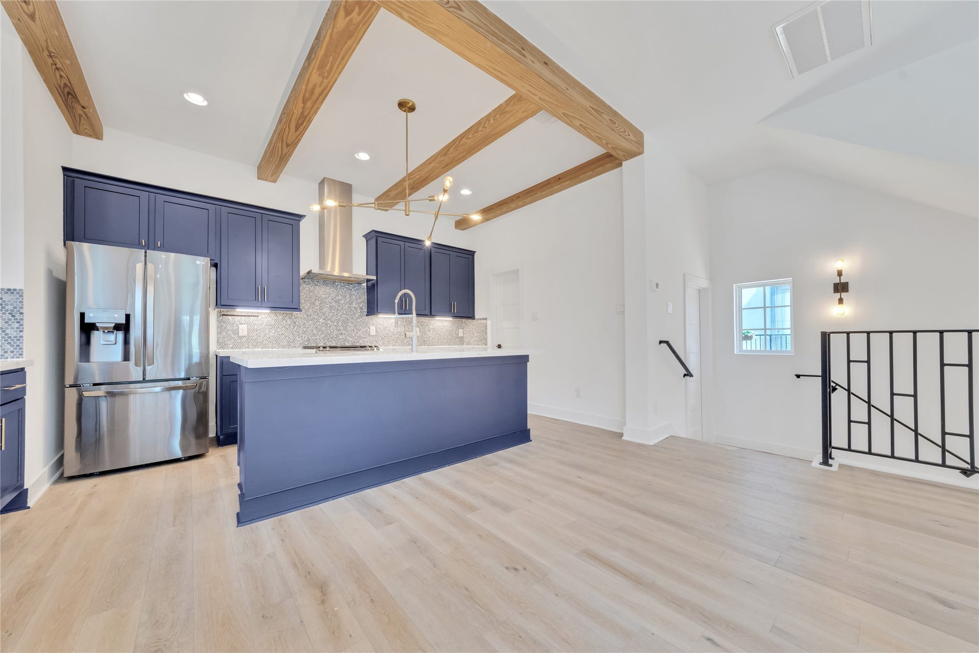 1035 W 24th Street, Houston, TX 77008 The chef's kitchen on the second floor has beautiful wood beams, custom marble backsplash, a wine fridge, gas cooking, and gleaming quartz countertops.