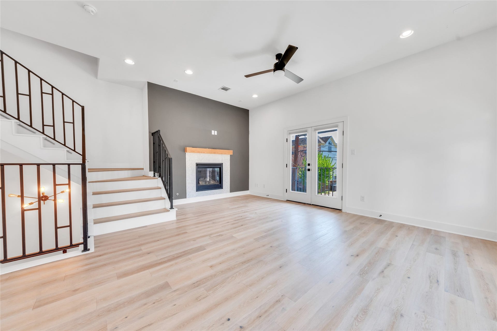 1035 W 24th Street, Houston, TX 77008 Living room with a fireplace and freshly painted leading to the balcony.