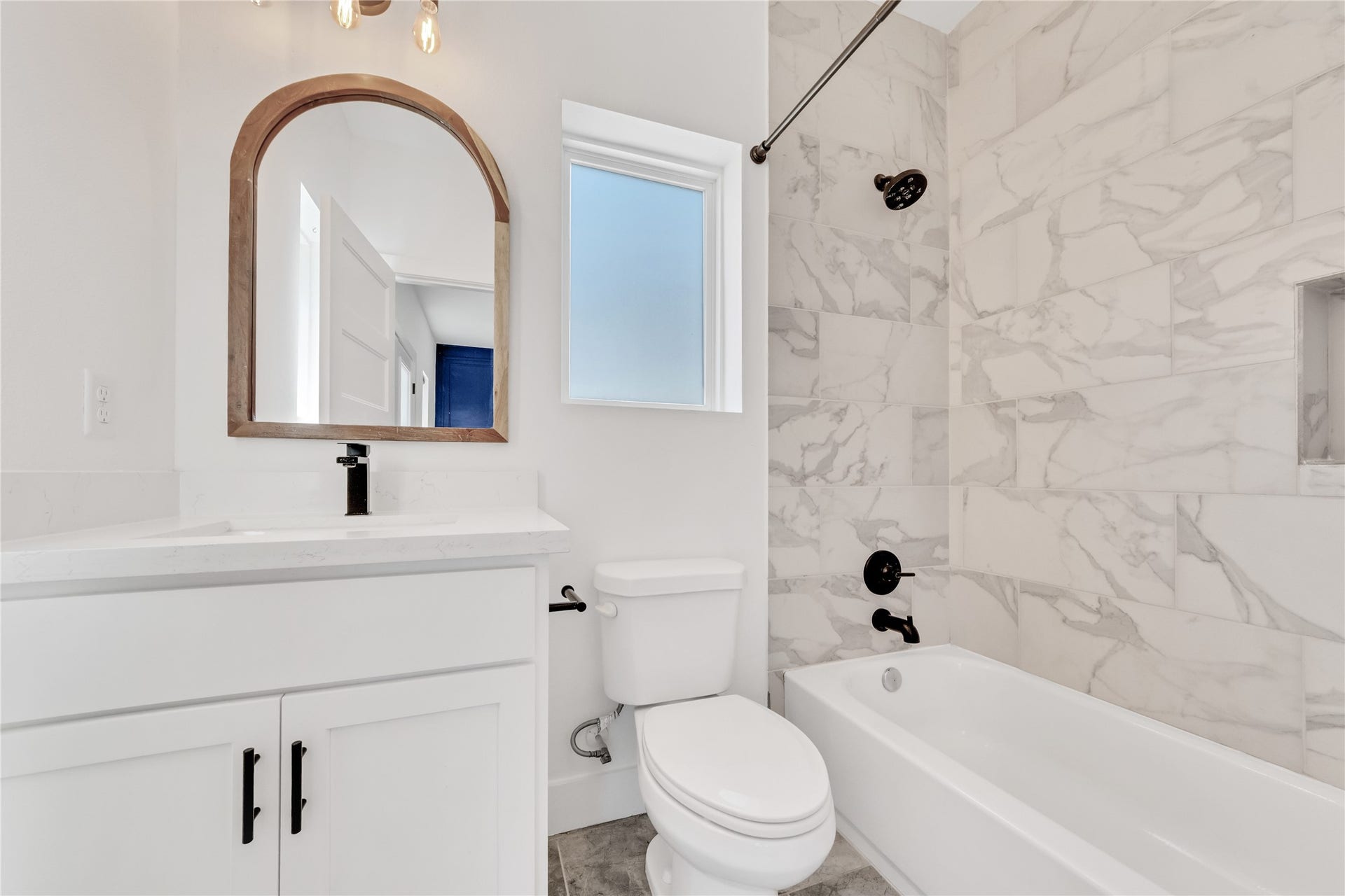 1035 W 24th Street, Houston, TX 77008 First floor full bathroom includes a shower/bath combo and vanity with storage.