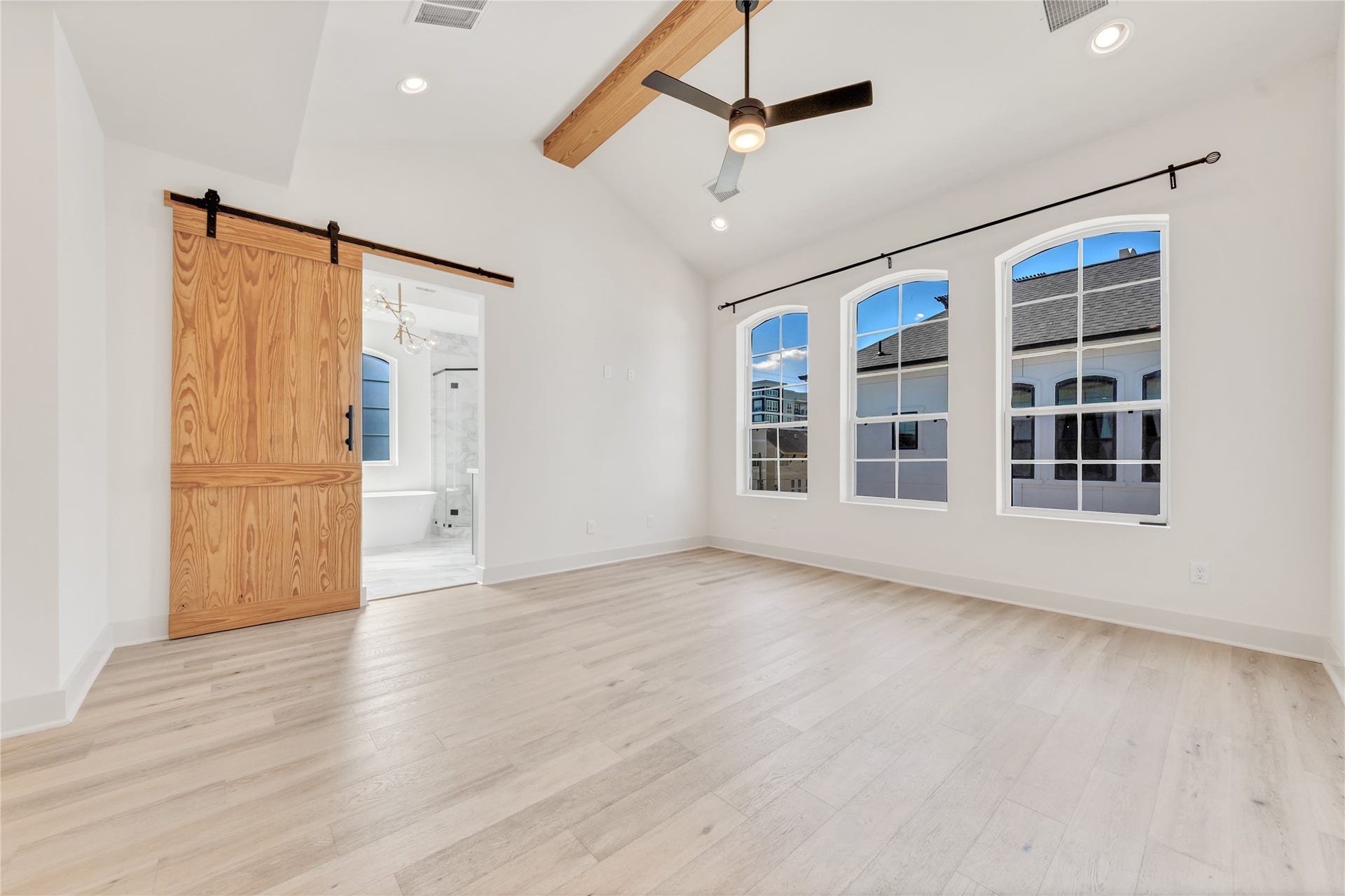 1035 W 24th Street, Houston, TX 77008 The primary suite on the third floor has a vaulted ceiling, tons of natural light, a farmhouse door leading to the designer bathroom, and hardwood flooring.