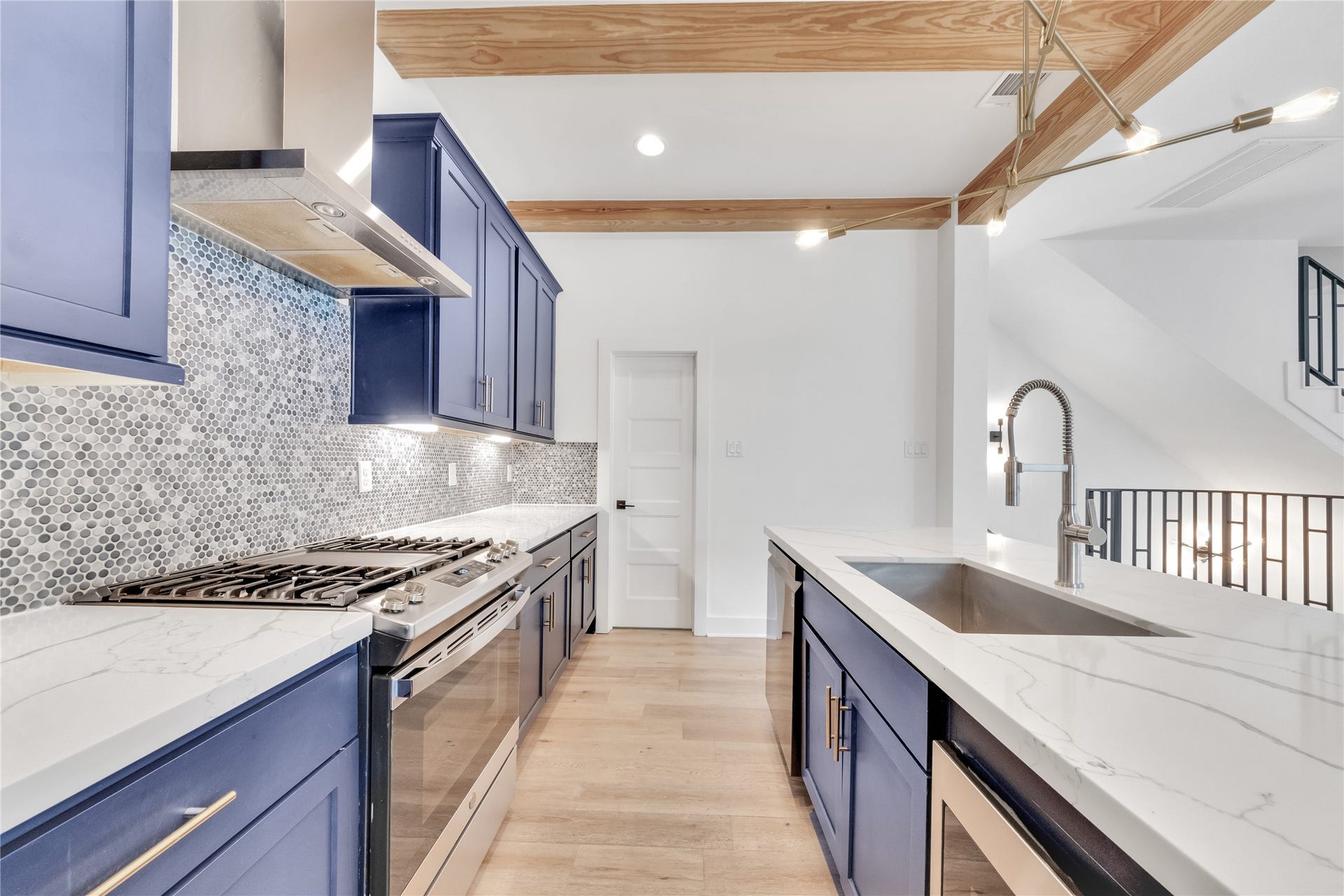 1035 W 24th Street, Houston, TX 77008 Stainless steel appliances include this gas range, vent, and deep single basin stainless sink. Custom cabinet hardware with under cabinet lighting!