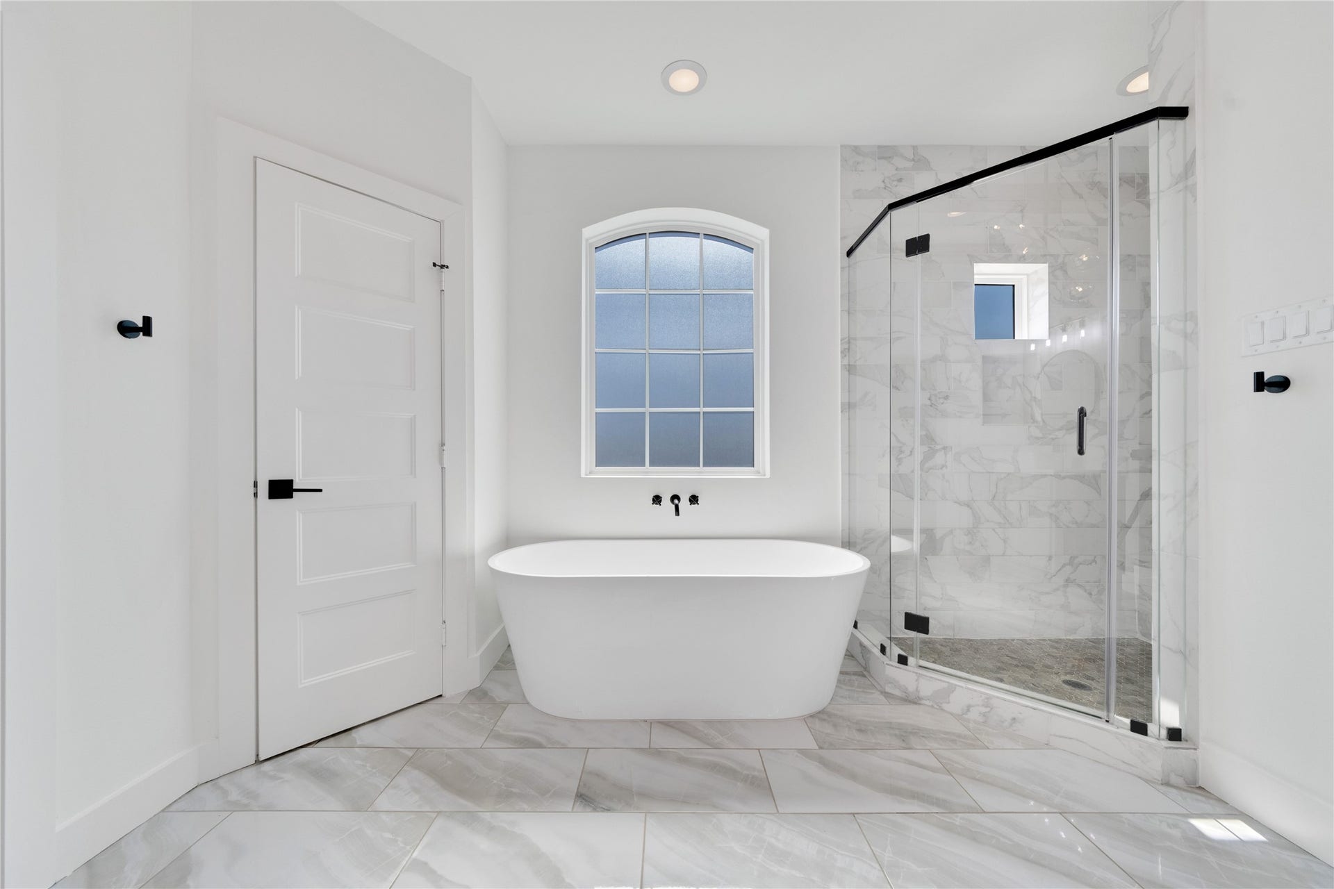 1035 W 24th Street, Houston, TX 77008 The primary bathroom has a soaking tub, spacious shower, custom lighting and mirrors, and the wood beams are continued through here for a designer touch.