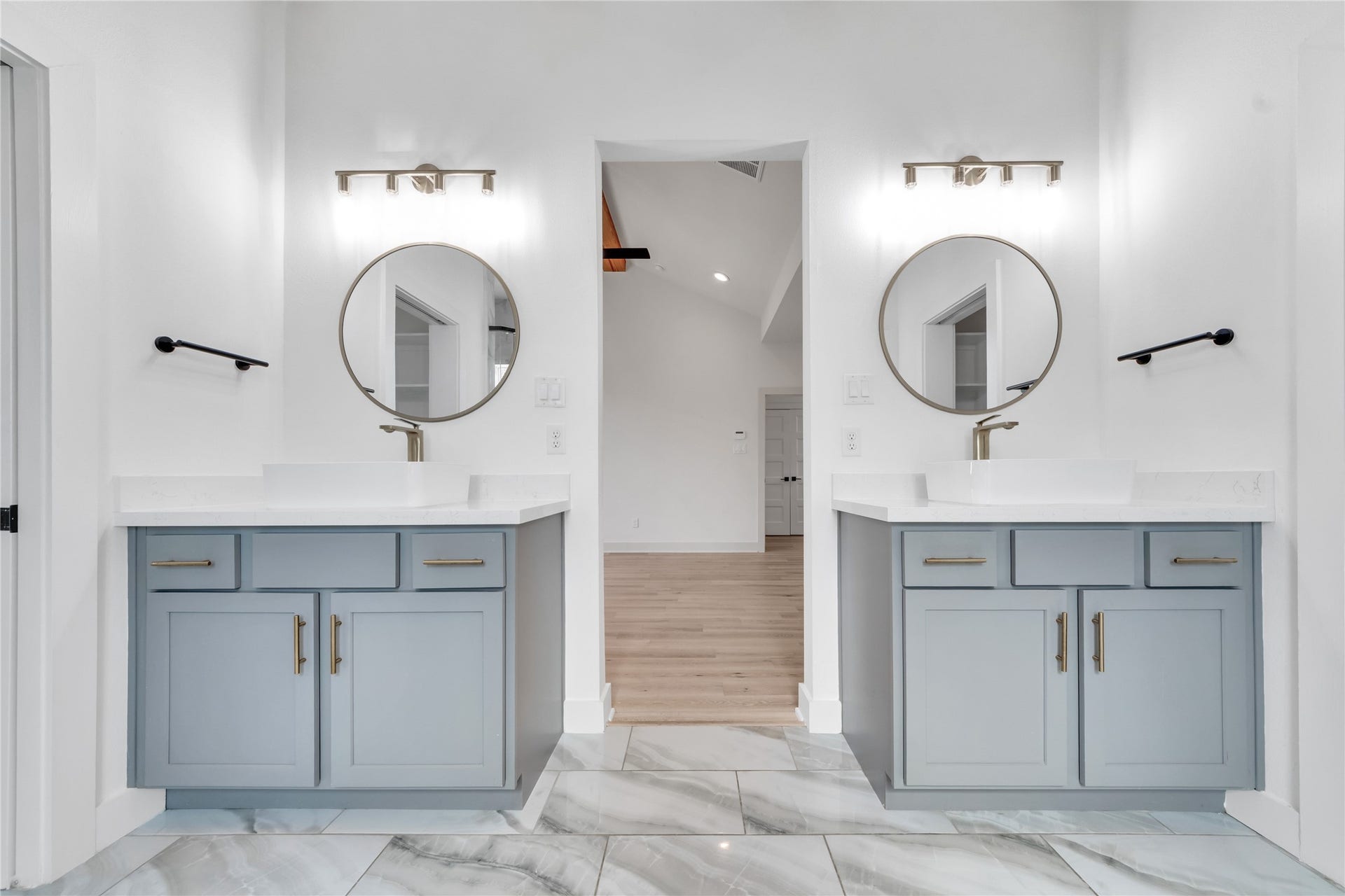 1035 W 24th Street, Houston, TX 77008 The primary bathroom has dual vanities, a soaking tub, spacious shower, custom lighting and mirrors, and the wood beams are continued through here for a designer touch.