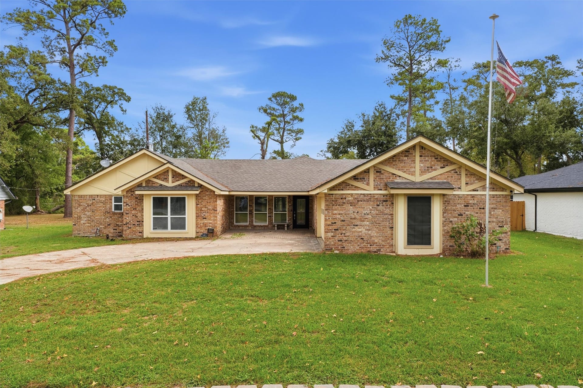 1718 Laurel Springs Lane, Kingwood, TX 77339 Daytime view of the home highlighting the covered front entry and decorative wood gables.