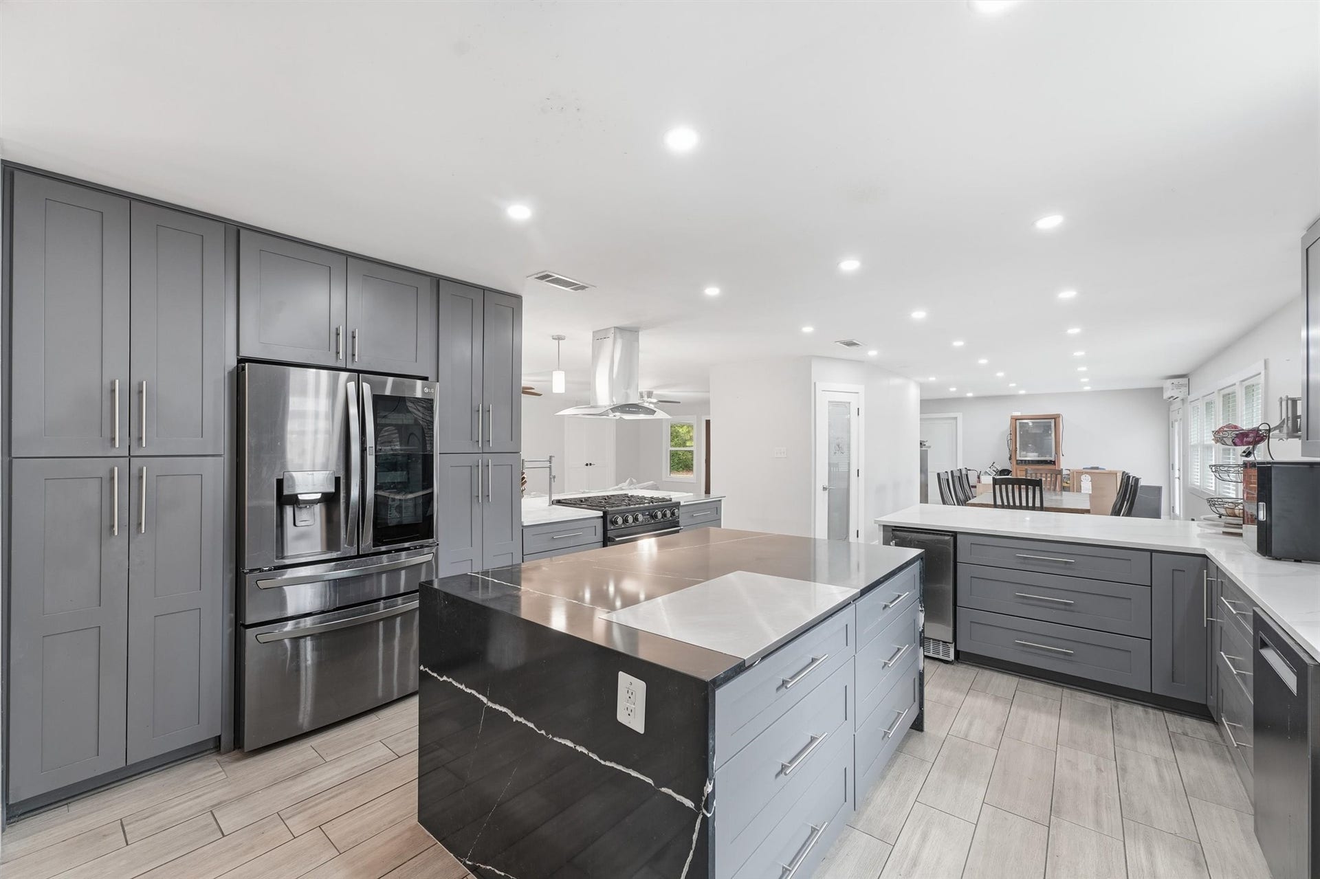 1718 Laurel Springs Lane, Kingwood, TX 77339 The kitchen includes a center island with additional storage, floor-to-ceiling cabinetry, stainless steel refrigerator, updated appliances, and a pantry conveniently located near the adjoining dining/breakfast area.