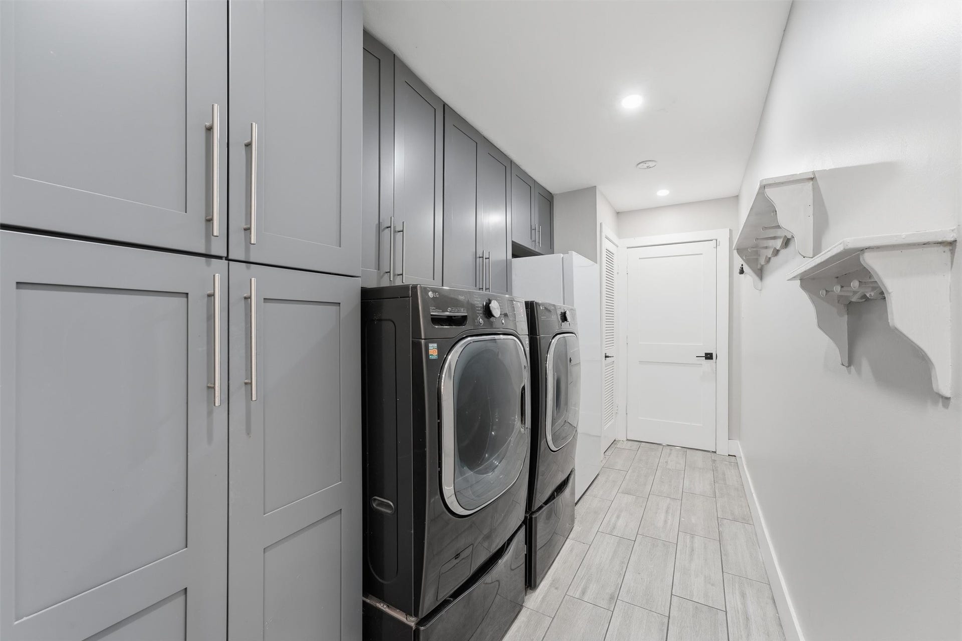 1718 Laurel Springs Lane, Kingwood, TX 77339 The laundry room offers floor-to-ceiling cabinetry, additional overhead storage, and room for a full-size washer and dryer.