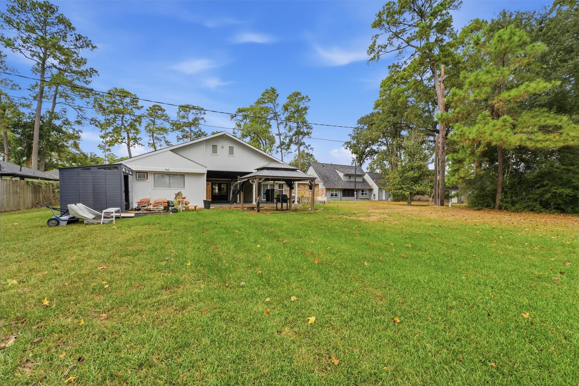 1718 Laurel Springs Lane, Kingwood, TX 77339 Another view from the back of the property highlights the large backyard and open lawn. With plenty of room for recreation or future outdoor improvements, this backyard offers a variety of possibilities.