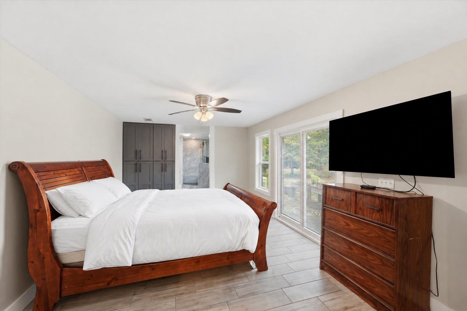 1718 Laurel Springs Lane, Kingwood, TX 77339 The second primary suite offers a comfortable amount of space, large sliding doors for natural light, and a private bathroom, making it a practical option for extended household living.