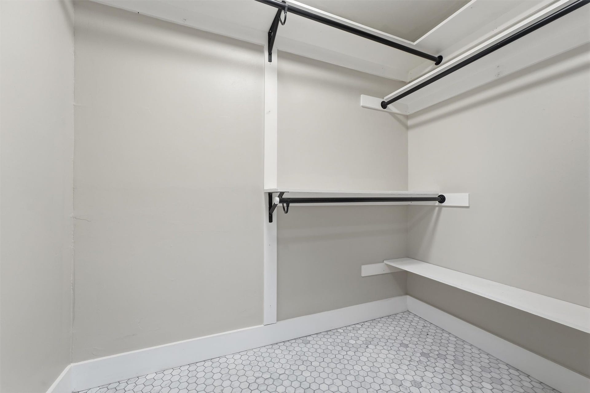 1718 Laurel Springs Lane, Kingwood, TX 77339 The second primary suite includes a walk-in closet conveniently located off the bathroom, with multiple hanging rods, storage shelves, and hexagonal tile flooring.