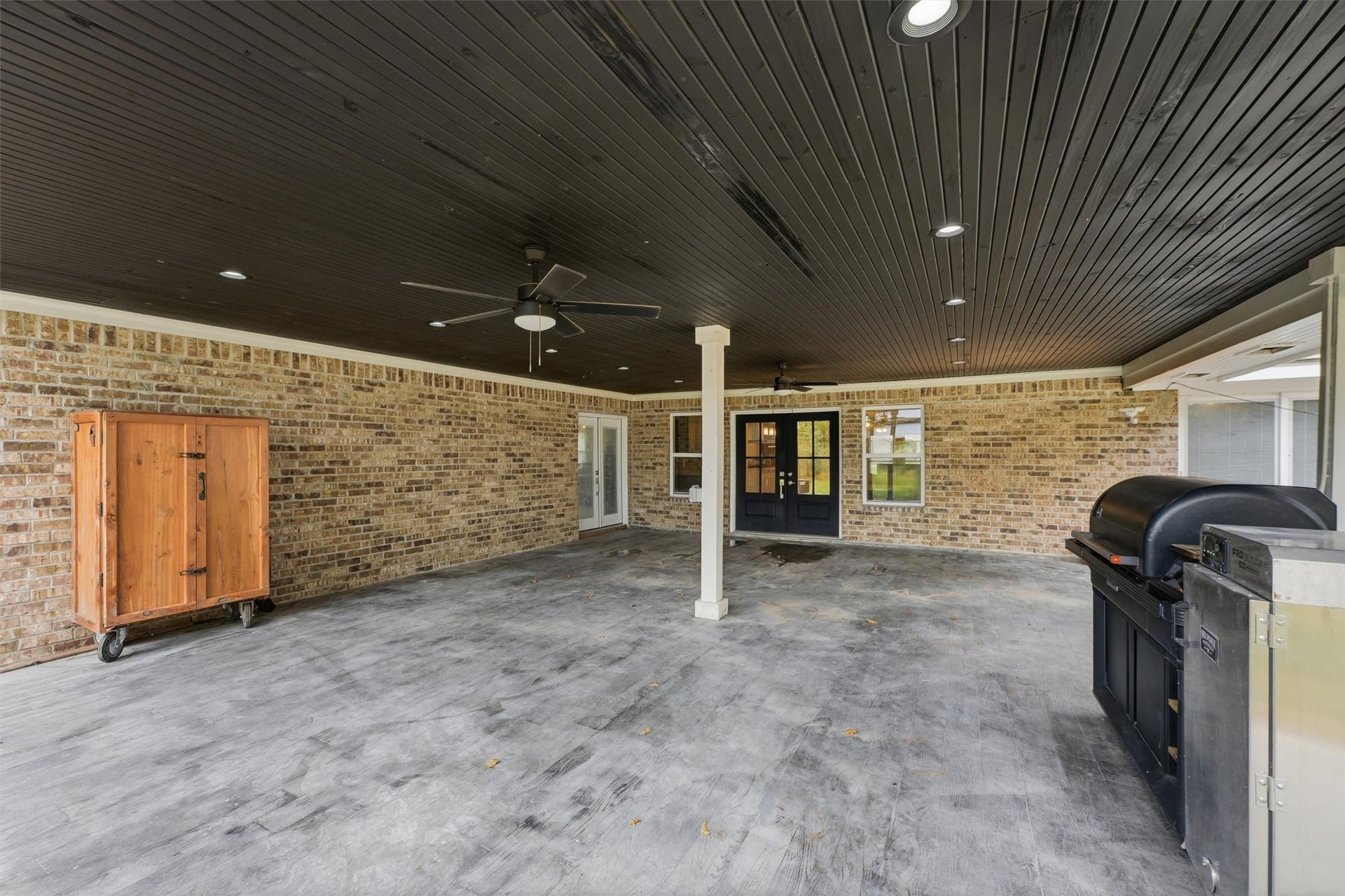 1718 Laurel Springs Lane, Kingwood, TX 77339 This expansive covered back patio, accessible from the living room and breakfast/dining area, offers a welcoming space for outdoor entertaining and relaxation. A dark wood-paneled ceiling, recessed lighting create a comfortable setting for gatherings year-round.