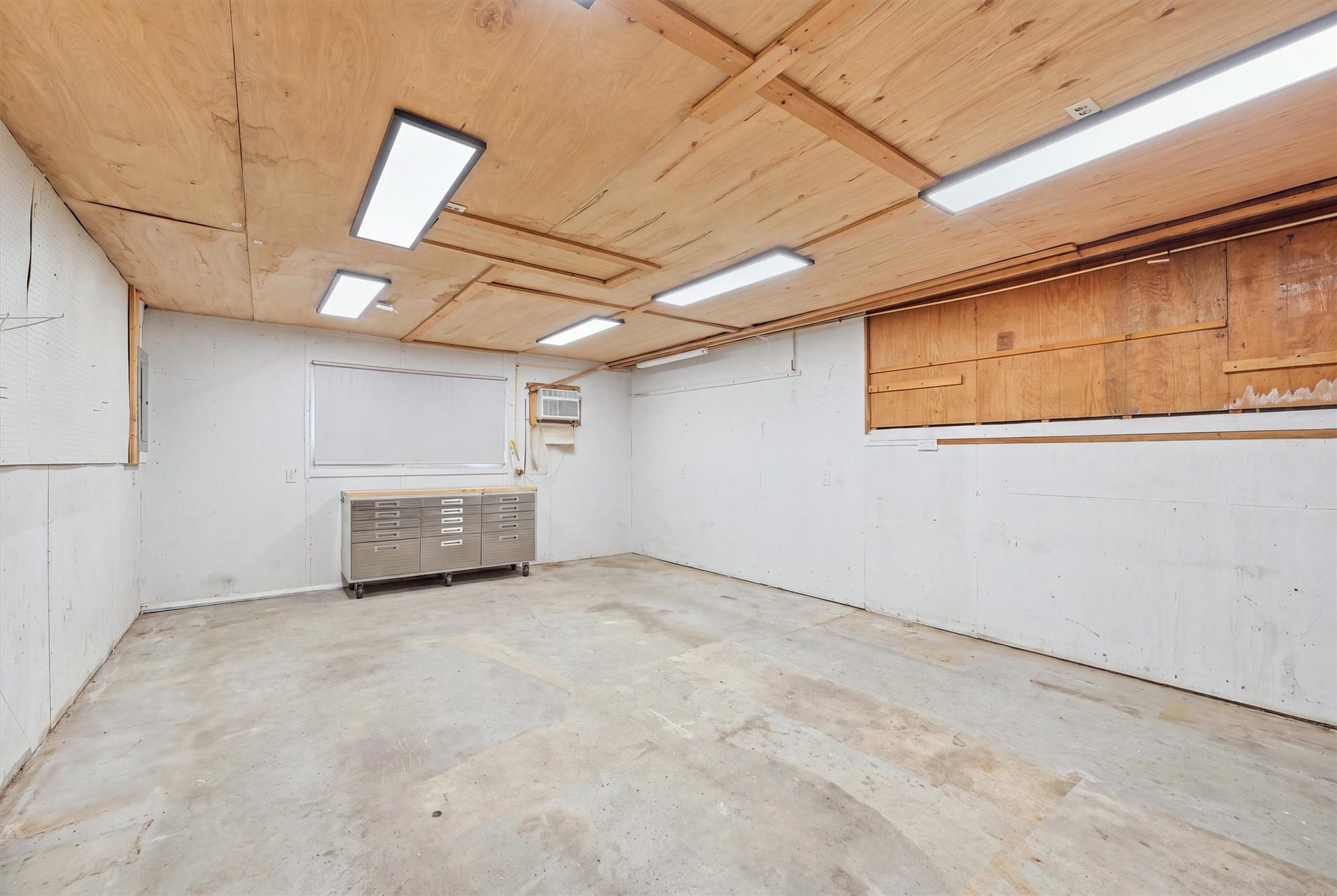 1718 Laurel Springs Lane, Kingwood, TX 77339 Located just off the dining and breakfast area, this dedicated indoor workshop offers a separate space for woodworking, DIY projects, and hobbies, with concrete flooring and overhead lighting.