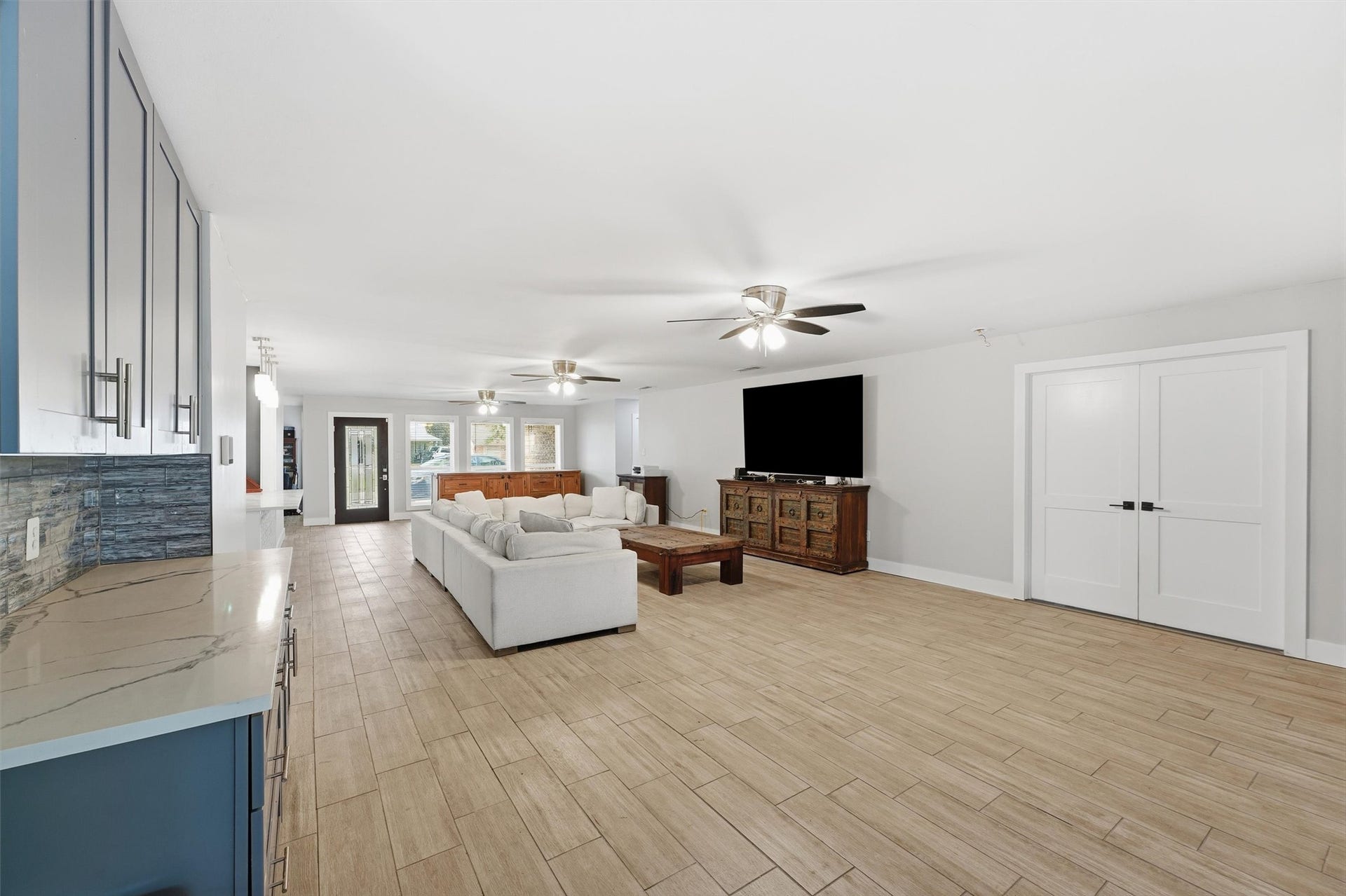 1718 Laurel Springs Lane, Kingwood, TX 77339 The large living area offers plenty of room for furniture and entertaining, with an adjoining butler's pantry featuring dark cabinetry, quartzite countertops, and tile backsplash.