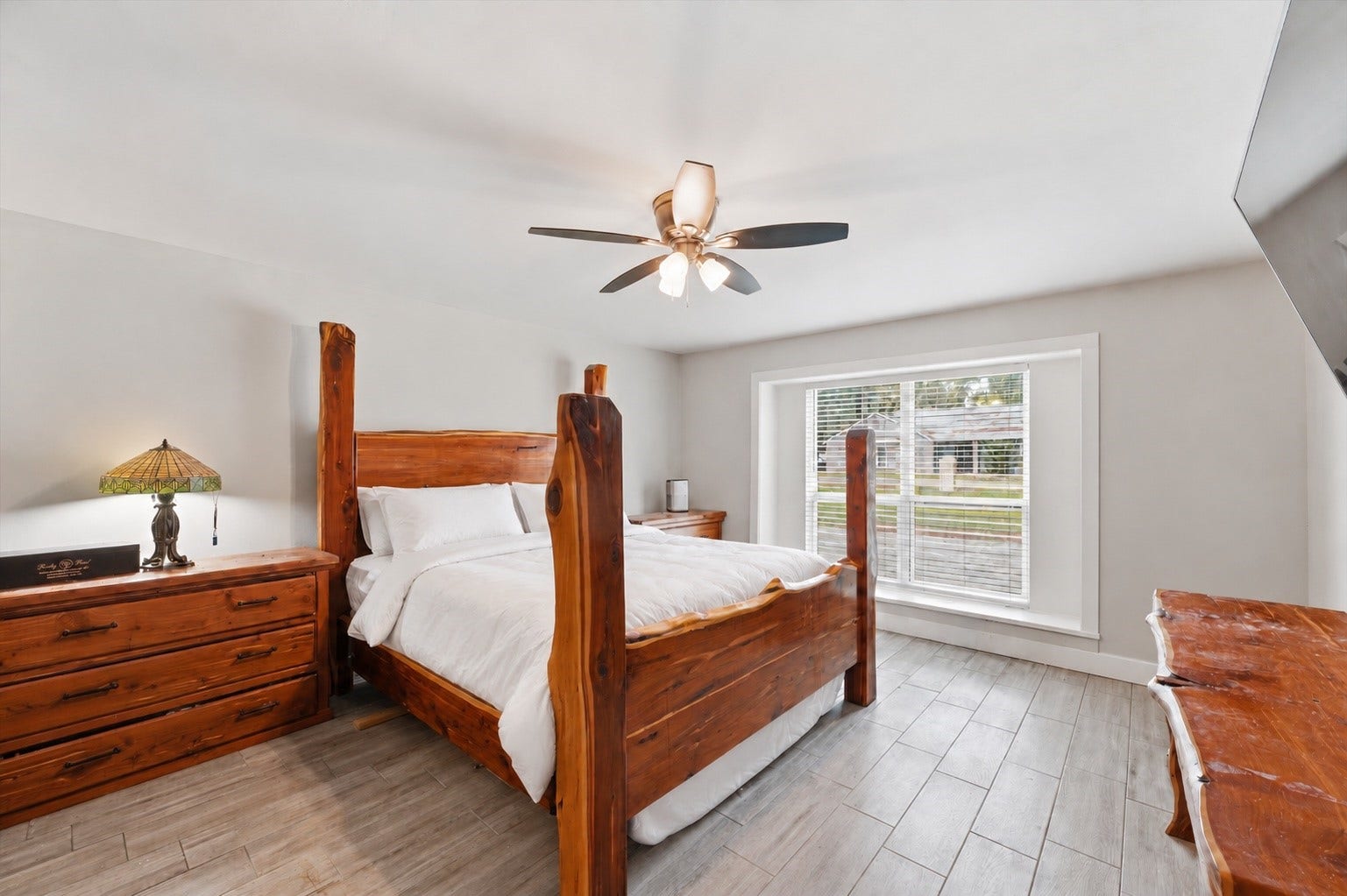 1718 Laurel Springs Lane, Kingwood, TX 77339 The main primary suite offers an expansive layout with wood-like tile flooring and plenty of room to create a comfortable, relaxing retreat.