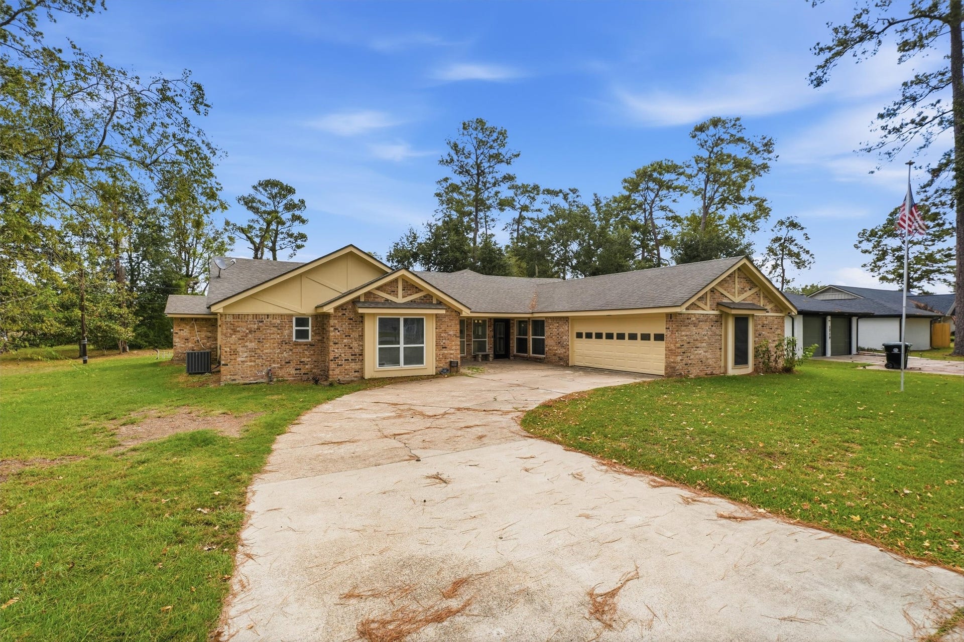 1718 Laurel Springs Lane, Kingwood, TX 77339 The home features a 30-year architectural dimensional shingle roof installed in 2024, along with a curved driveway leading to the attached garage.
