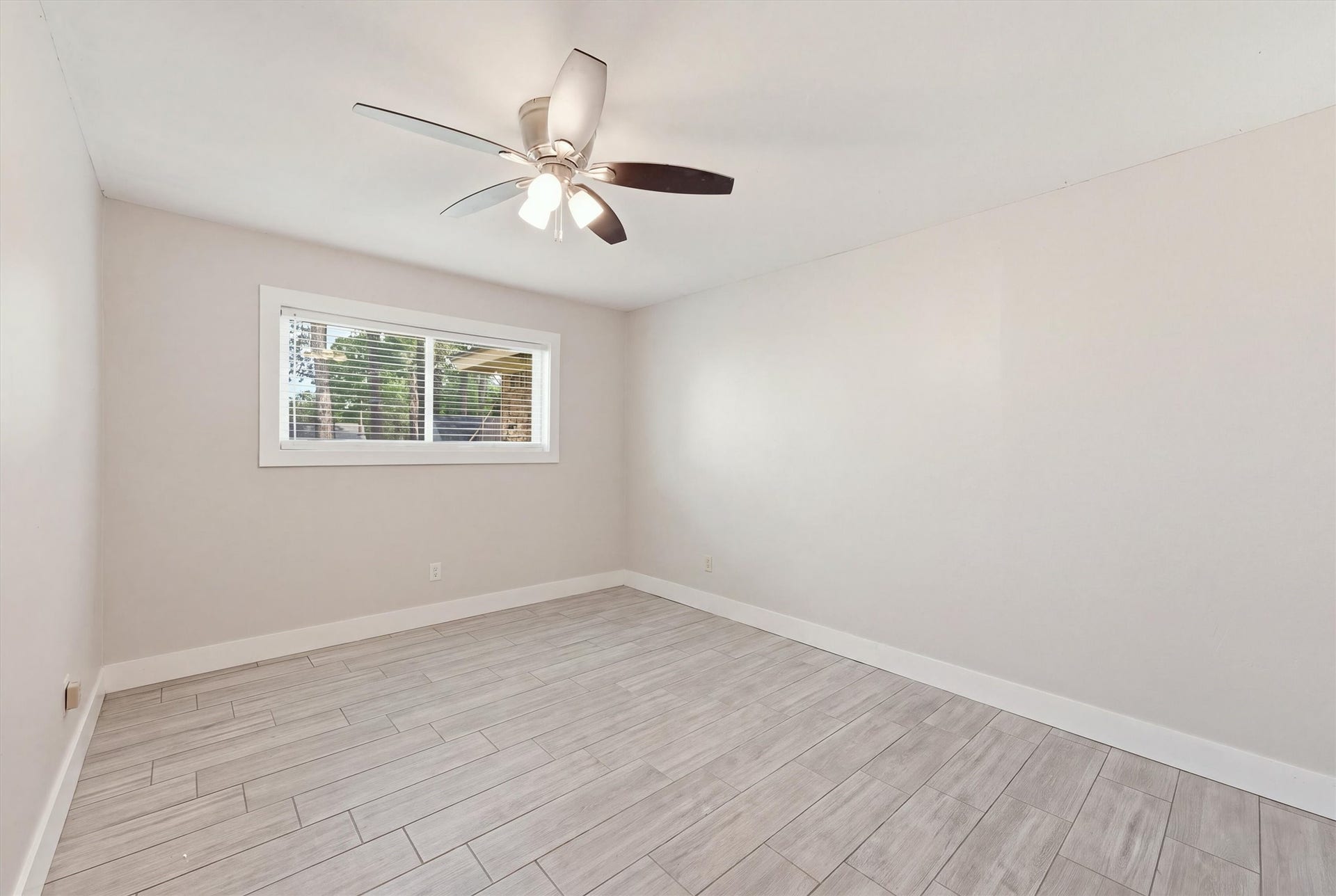 1718 Laurel Springs Lane, Kingwood, TX 77339 The third bedroom features wood-like tile flooring, neutral wall colors, and a functional layout that offers flexibility for guests or everyday use.