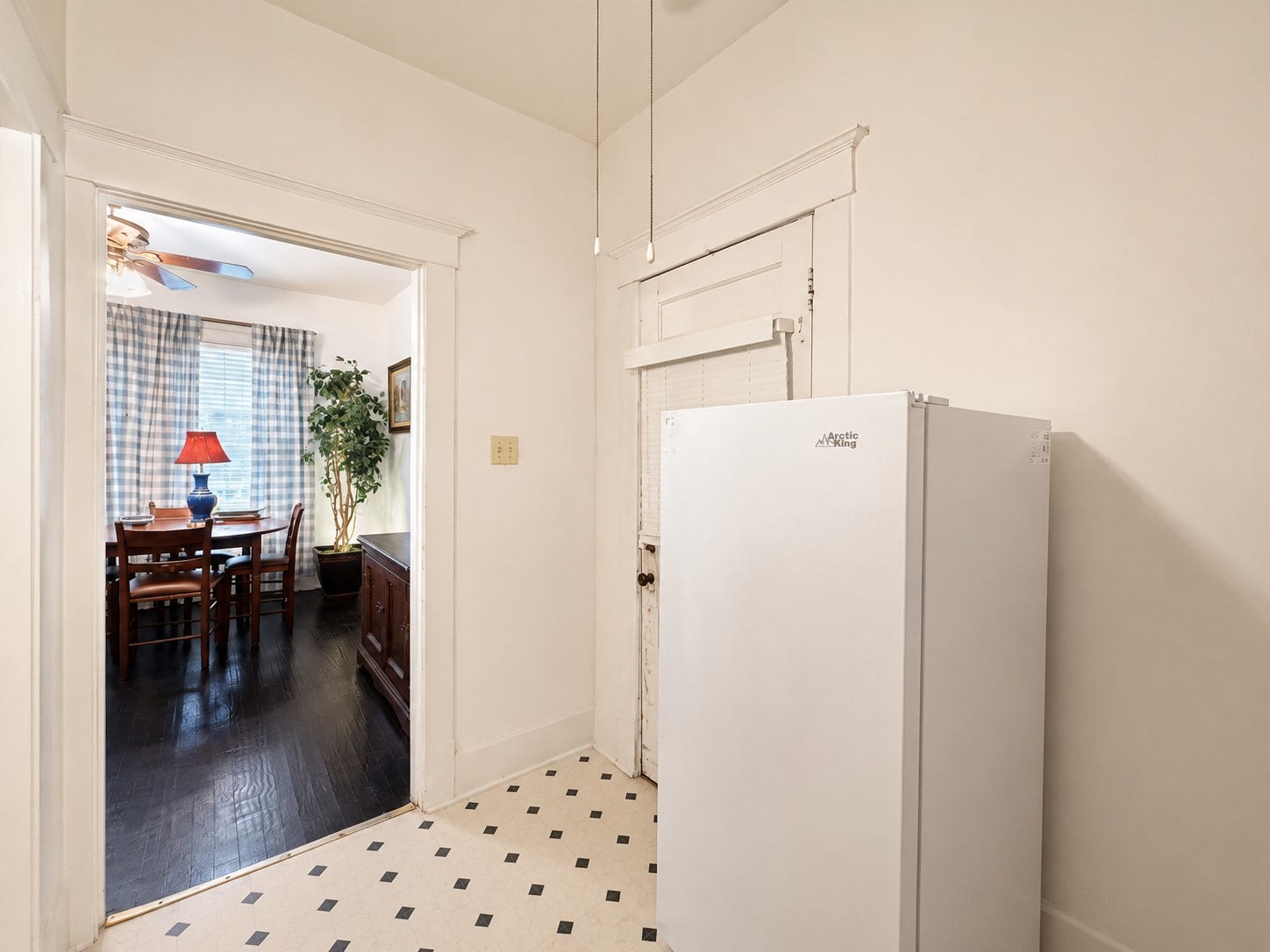 Alternate view shows the connection between this flexible utility space and the adjoining living area, with high ceilings and traditional trim continuing the homes character.