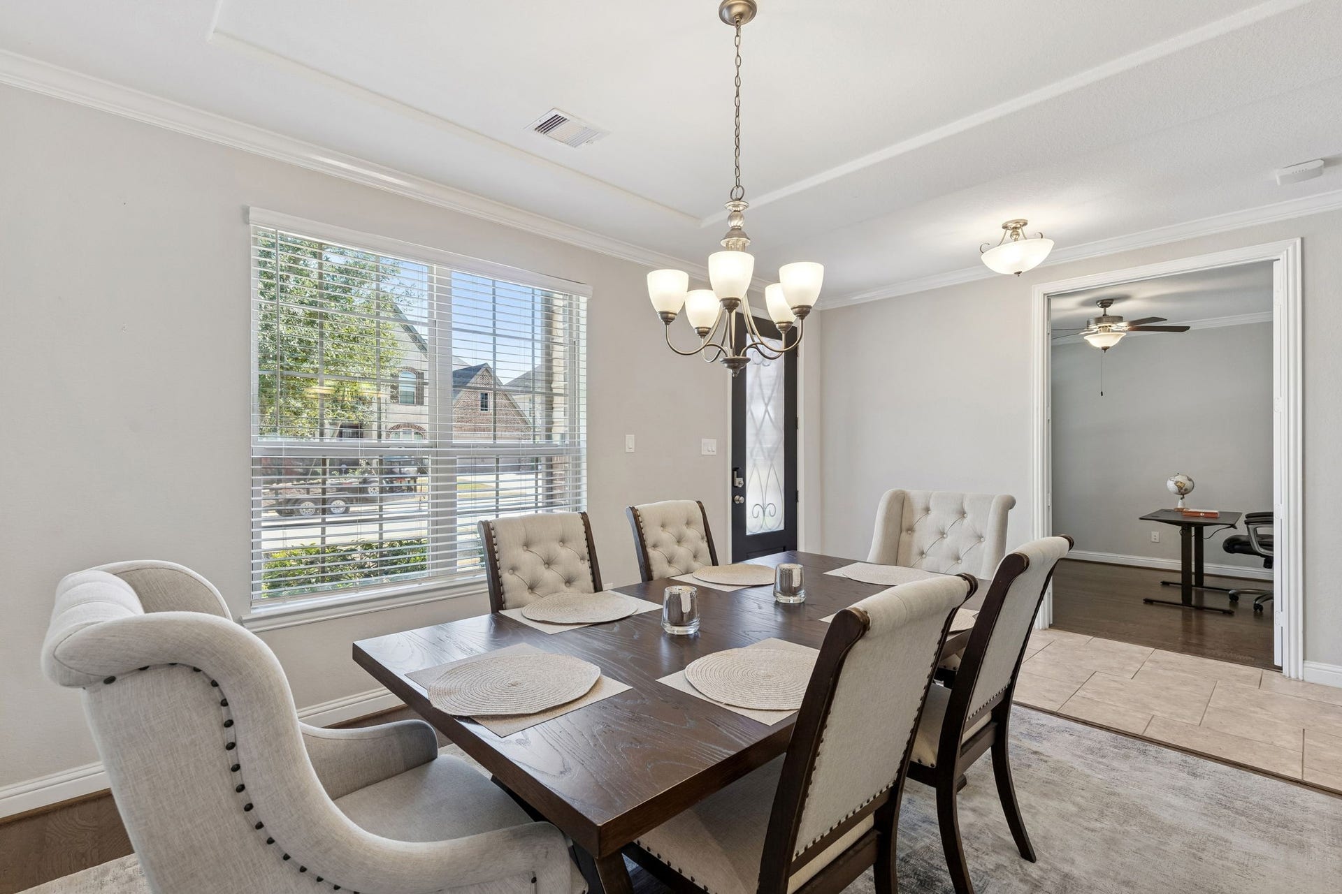 1619 Dove Ridge Drive, Katy, TX 77493 Host unforgettable dinners in this light-filled formal dining room featuring elegant crown molding, a statement chandelier, and oversized front-facing windows that flood the space with natural light. The open flow to the adjoining flex room makes it perfect for entertaining, a home office, or an additional sitting area to fit your lifestyle.