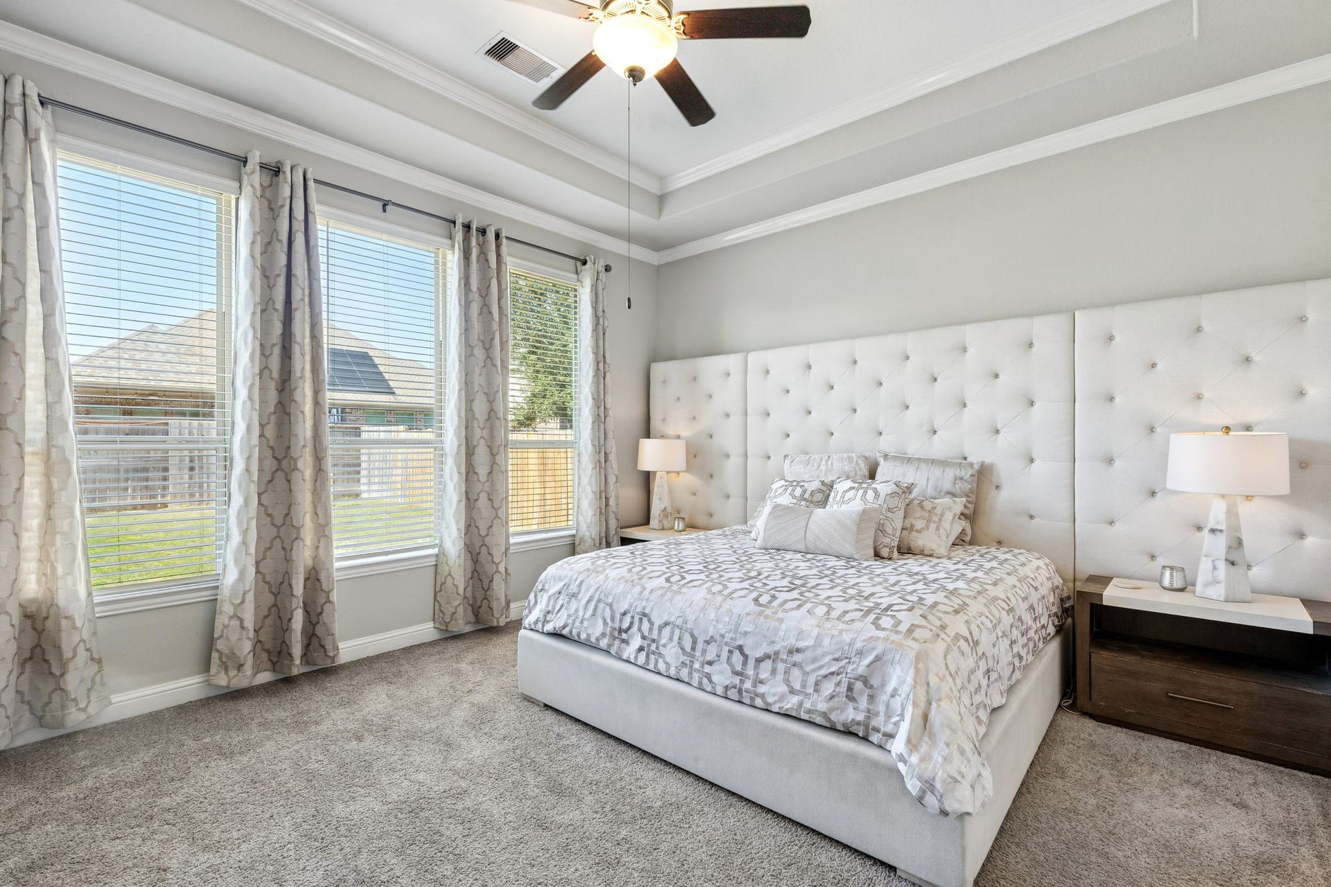 1619 Dove Ridge Drive, Katy, TX 77493 Unwind in this spacious first-floor primary suite featuring a tray ceiling with crown molding, oversized windows that fill the room with natural light, and plush carpeting underfoot. The elegant neutral palette and generous layout create a peaceful retreat youll look forward to coming home to every day.