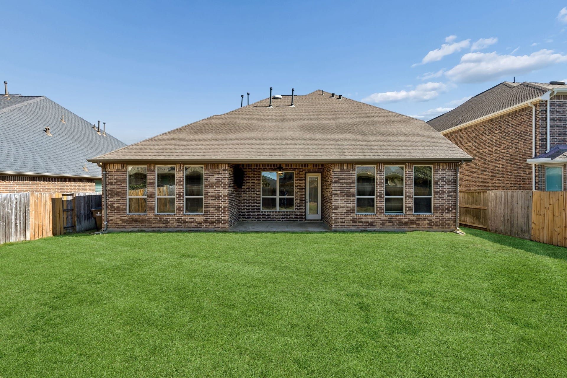 1619 Dove Ridge Drive, Katy, TX 77493 The expansive, fully fenced backyard offers a lush lawn and professional landscaping. This private green space is perfect for outdoor activities and pets in the quiet Cane Island community.