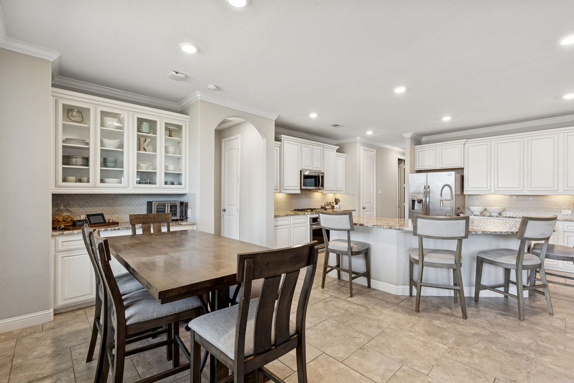 1619 Dove Ridge Drive, Katy, TX 77493 Bright and inviting breakfast area seamlessly connected to the chefs kitchenperfect for everyday living and effortless entertaining. Enjoy custom built-ins with glass cabinetry, abundant natural light, spacious island seating, and an open layout that keeps everyone connected. Whether its morning coffee or hosting friends, this warm and functional space is one youll want to experience in person.