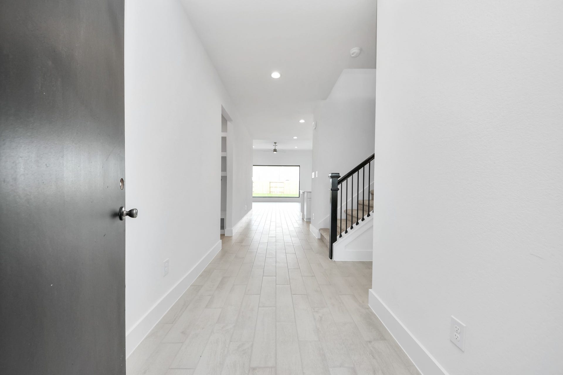 5906 Fox Peak Lane, Richmond, TX 77469 As you step into the threshold of this luxurious home, you'll soon be welcomed by an elegant glass door (to be installed). Inside, soaring ceilings amplify the spaciousness, while the refined wood-look tile flooring and oversized baseboards exude sophistication and charm. Sample photo of completed home with similar floor plan. Actual colors and selections may vary.