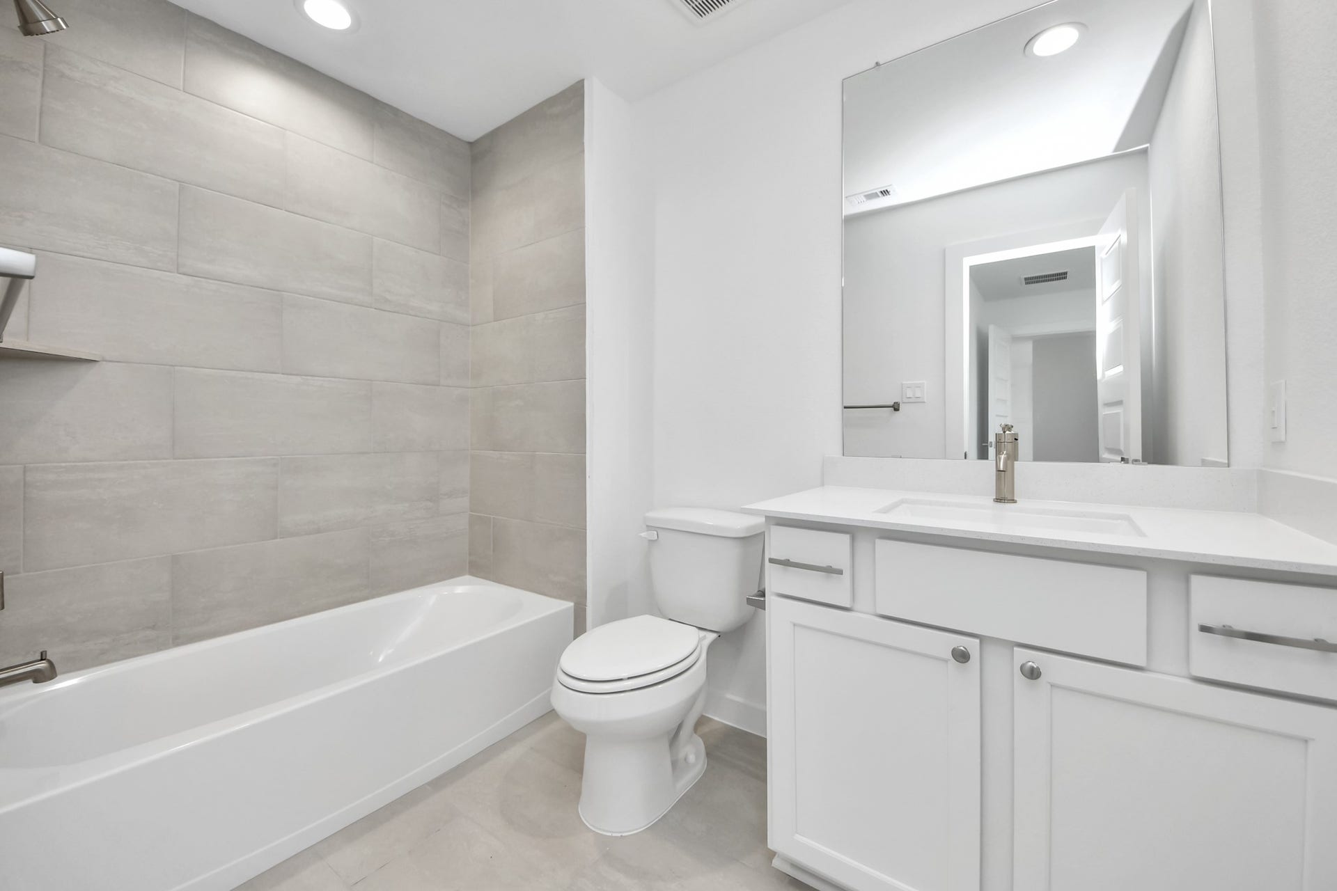 5906 Fox Peak Lane, Richmond, TX 77469 Secondary bath features tile flooring, bath/shower combo with tile surround, light stained wood cabinets, beautiful light countertop. Sample photo of completed home with similar floor plan. Actual colors and selections may vary.