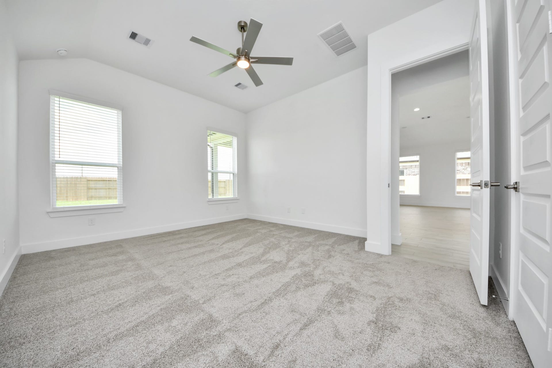 5906 Fox Peak Lane, Richmond, TX 77469 Come and unwind after a long day in this magnificent primary suite! This spacious room features plush carpet, warm paint, high ceilings and large windows with privacy blinds. Sample photo of completed home with similar floor plan. Actual colors and selections may vary.