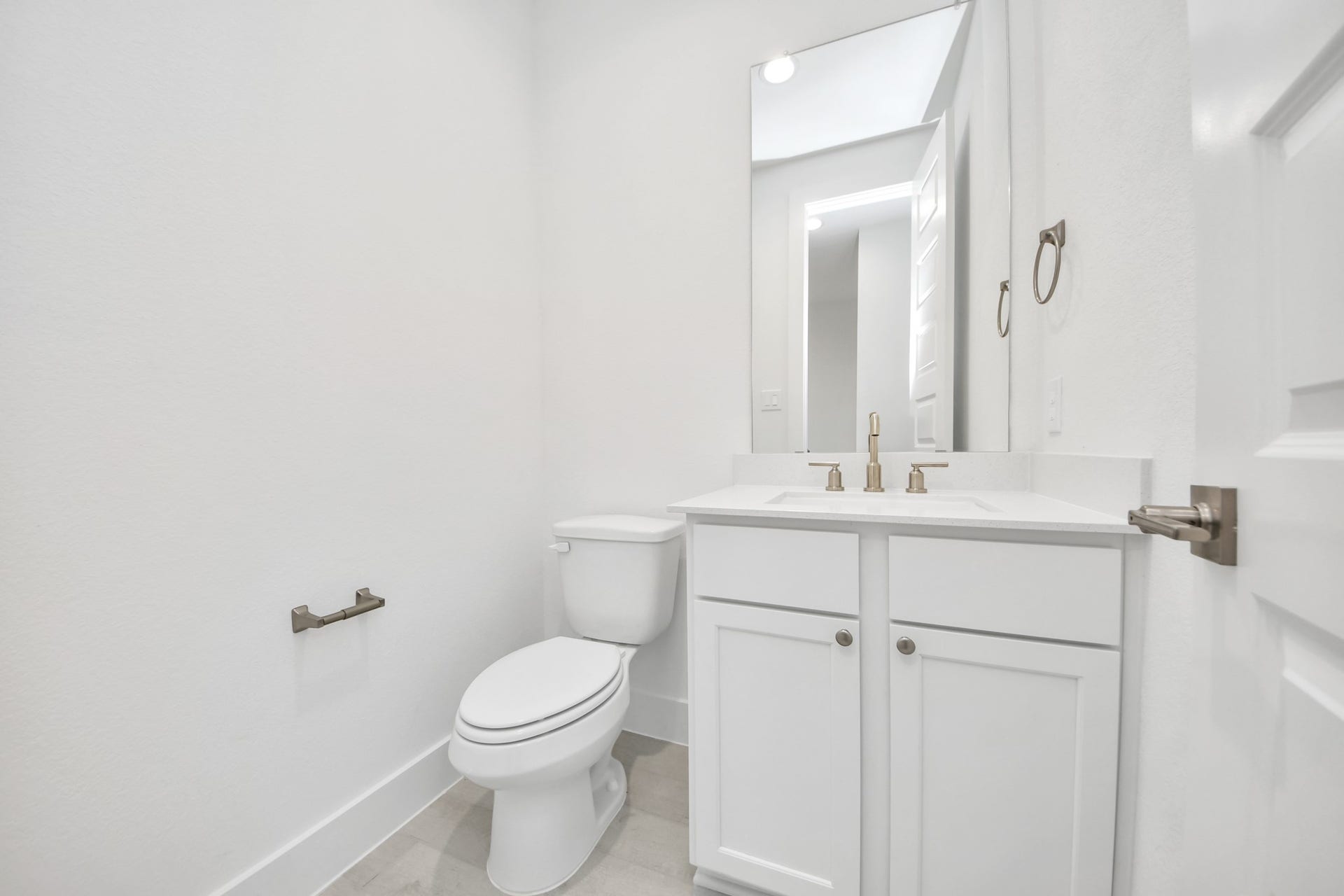 5906 Fox Peak Lane, Richmond, TX 77469 Sophisticated half bathroom adorned with contemporary finishes. The elegant 5-panel door welcomes you to a space where style meets functionality. Notice the sleek hardware accents that add a touch of modern charm. The vanity boasts light-colored countertops, beautifully complemented by a tasteful vanity light, creating a well-lit and inviting atmosphere. Sample photo of completed home with similar floor plan. Actual colors and selections may vary.