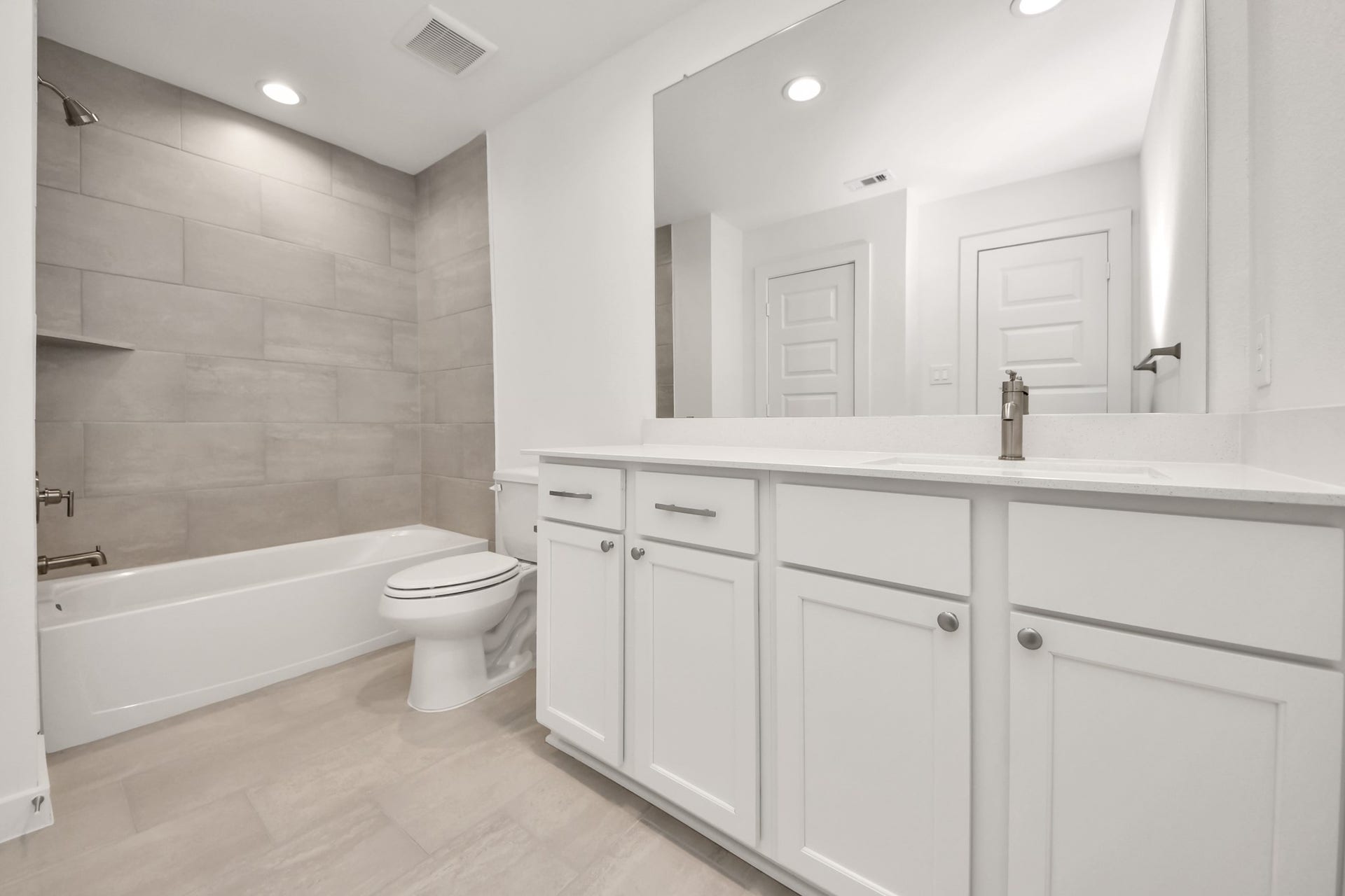 5906 Fox Peak Lane, Richmond, TX 77469 Secondary bath features tile flooring, bath/shower combo with tile surround, light stained wood cabinets, beautiful light countertop. Sample photo of completed home with similar floor plan. Actual colors and selections may vary.