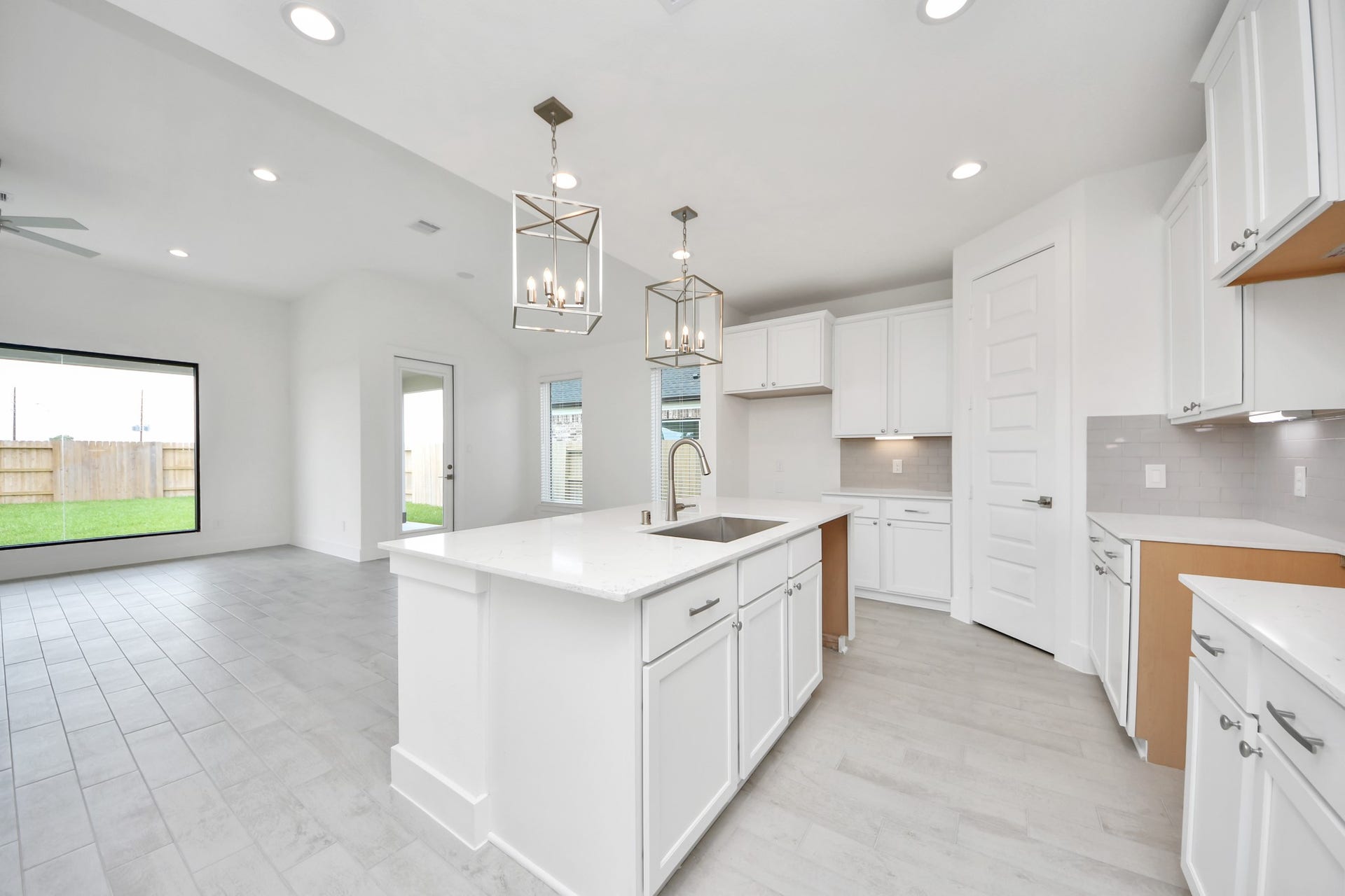 5906 Fox Peak Lane, Richmond, TX 77469 This kitchen is by far any chefs dream! This spacious kitchen features high ceilings, light stained wood cabinets, granite countertop, SS appliances, modern tile backsplash, recessed lighting, extended counter space, granite kitchen island with double sink, and space for breakfast bar, and a walk-in pantry all overlooking your huge family room. Sample photo of completed home with similar floor plan. Actual colors and selections may vary.